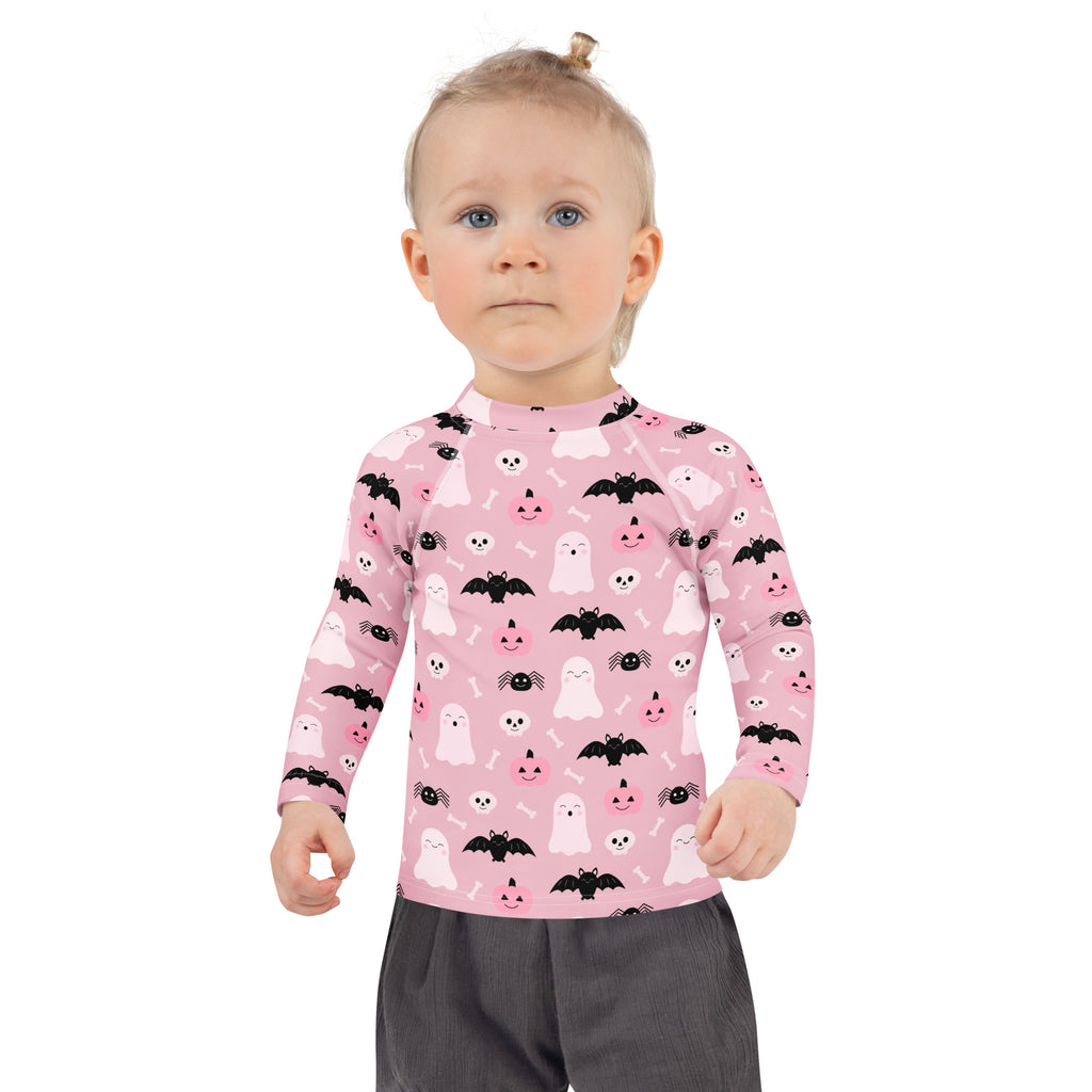 Girls pink long sleeve rash guard swim shirt with playful black and white ghosts bats pumpkins and spiders pattern