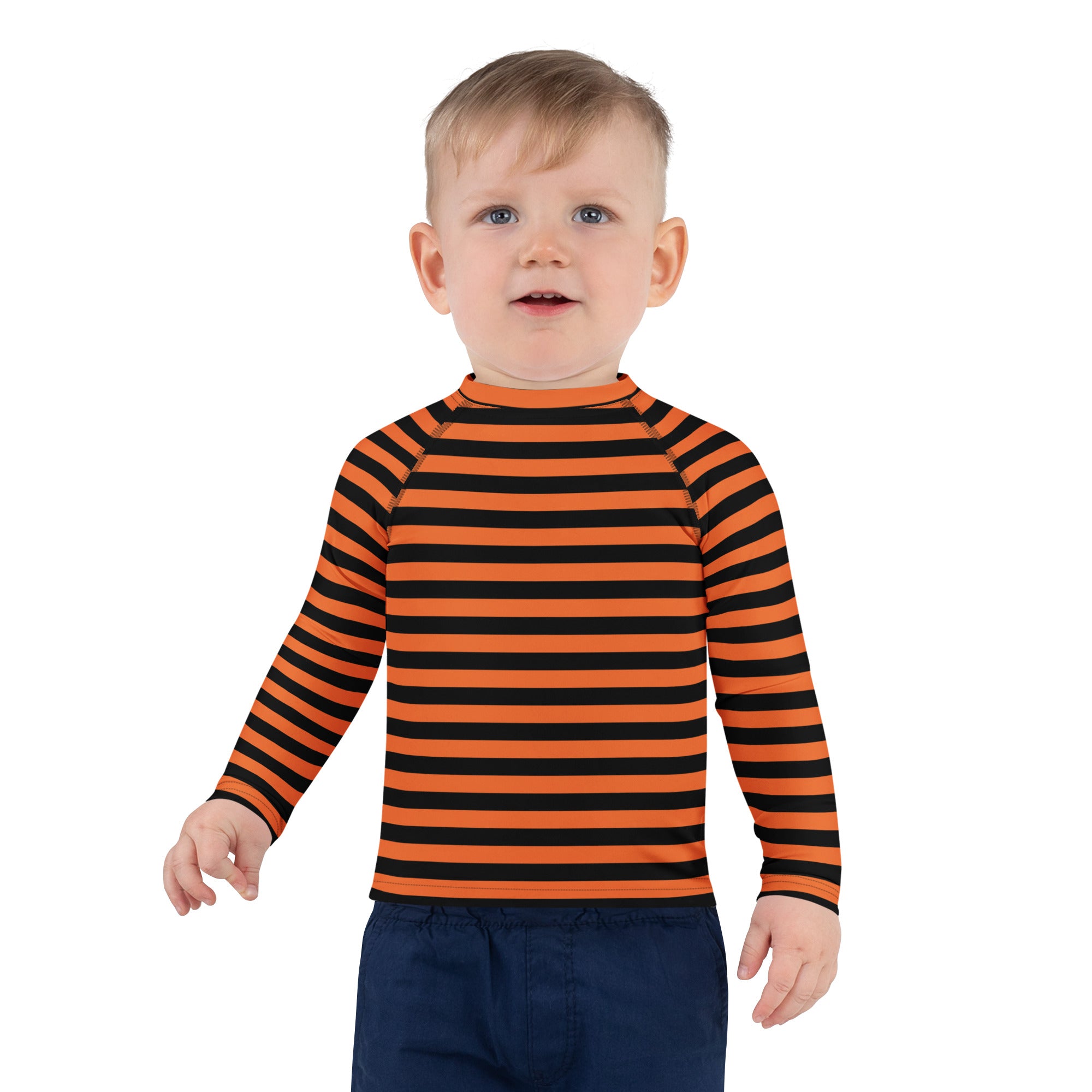 A child wearing a kids orange and black halloween long sleeve rash guard swim shirt with UPF 50+ protection