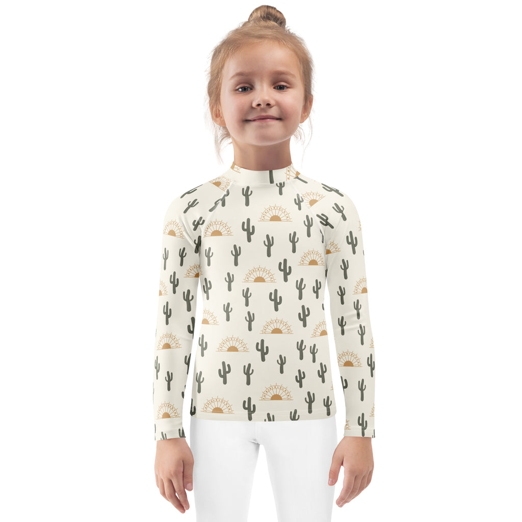 Kids cactus desert sunrise long sleeve rash guard swim shirt cream color with black and gold cactus and sun pattern upf 50+