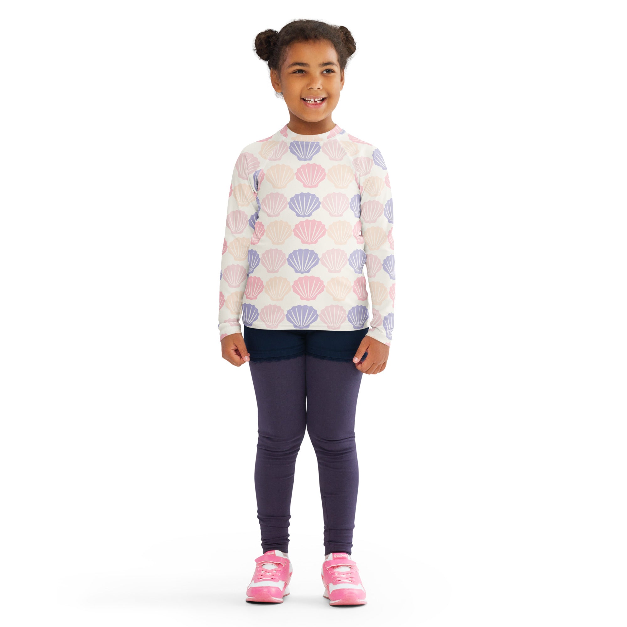 A child wearing a kids seashell print long sleeve rash guard swim shirt with upf 50 plus in pink and lavender seashells
