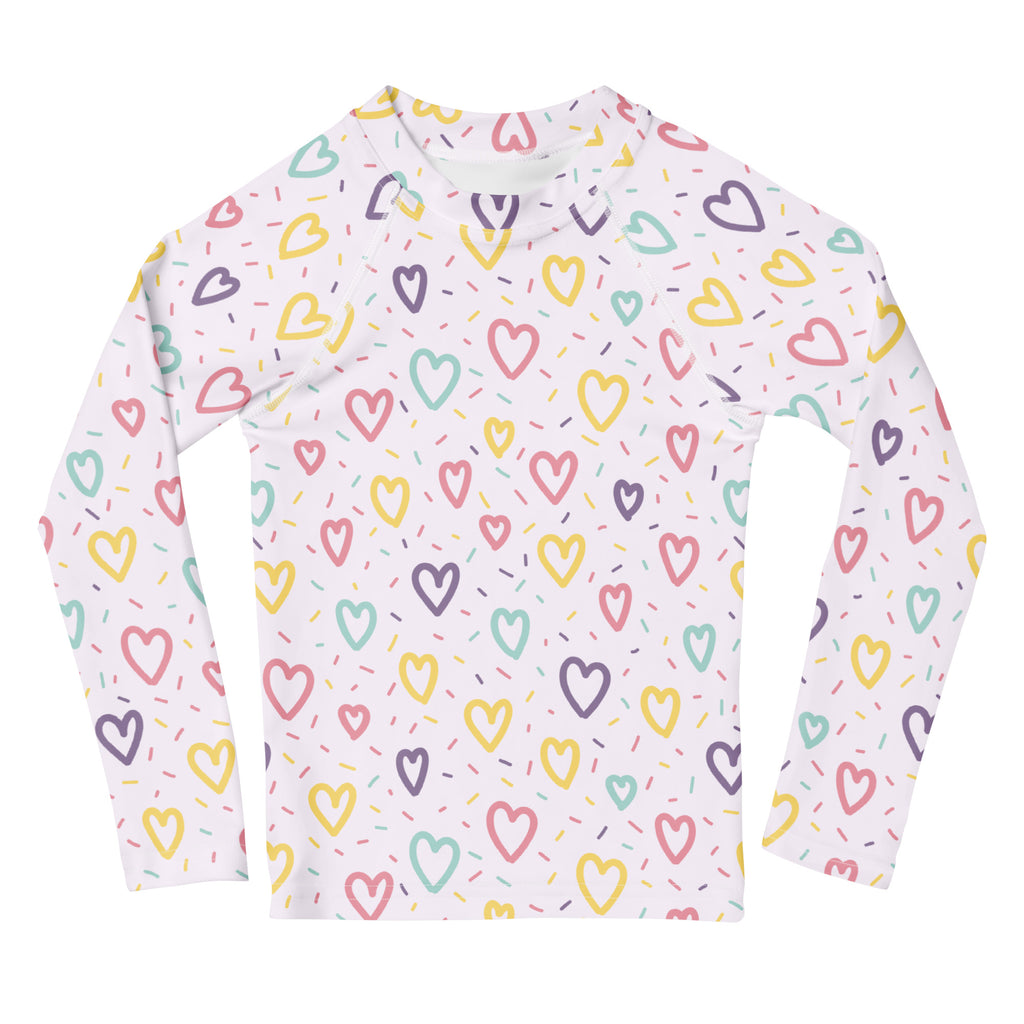 White long-sleeved girls rash guard swim shirt with multicolored hearts and sprinkles pattern and upf 50+ protection