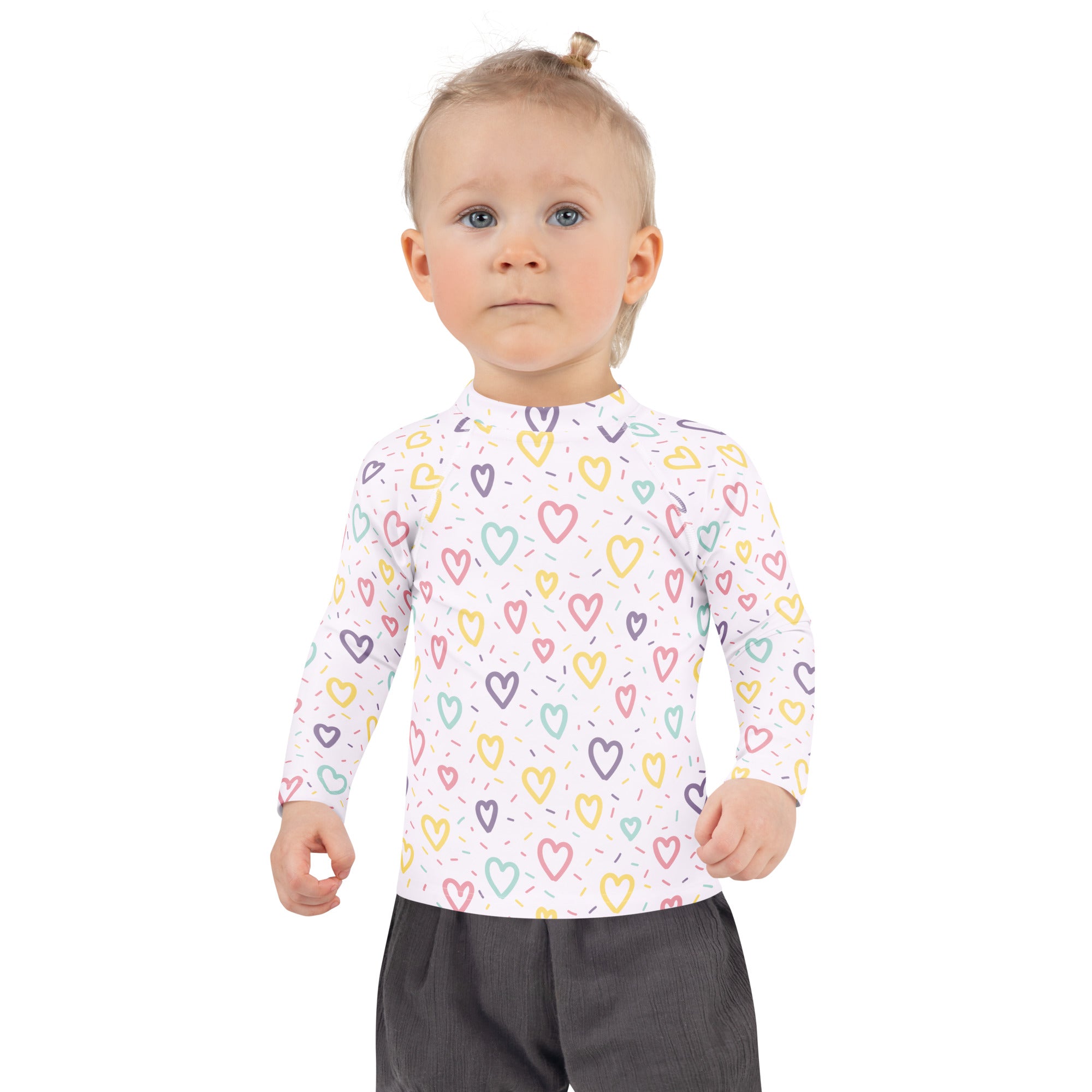 A child wearing a white girls hearts and sprinkles long sleeve rash guard swim shirt with colorful outlined hearts and UPF 50+