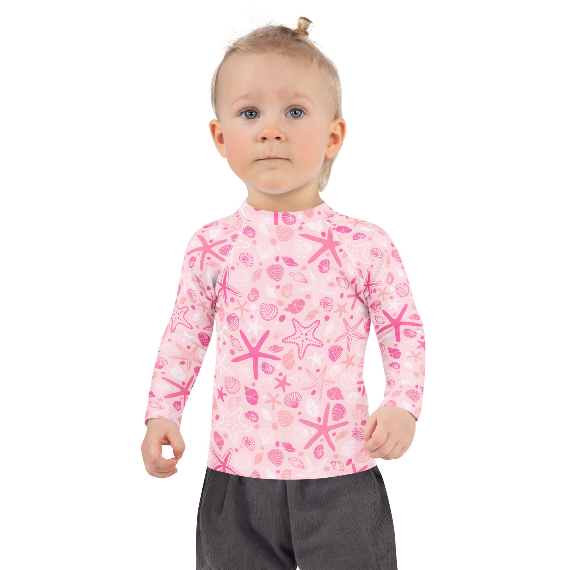 Girls pink long-sleeved rash guard swim shirt with playful starfish and seashell pattern and UPF 50+ protection