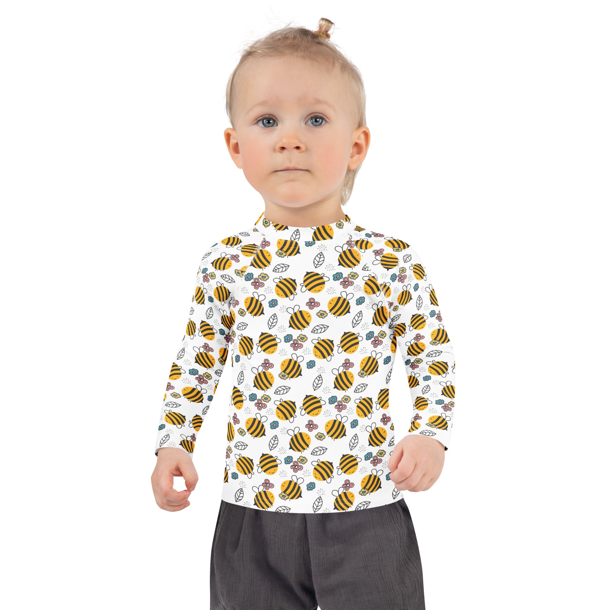 A child wearing a kids floral yellow bumblebee long sleeve rash guard swim shirt with upf 50 plus and playful bee pattern