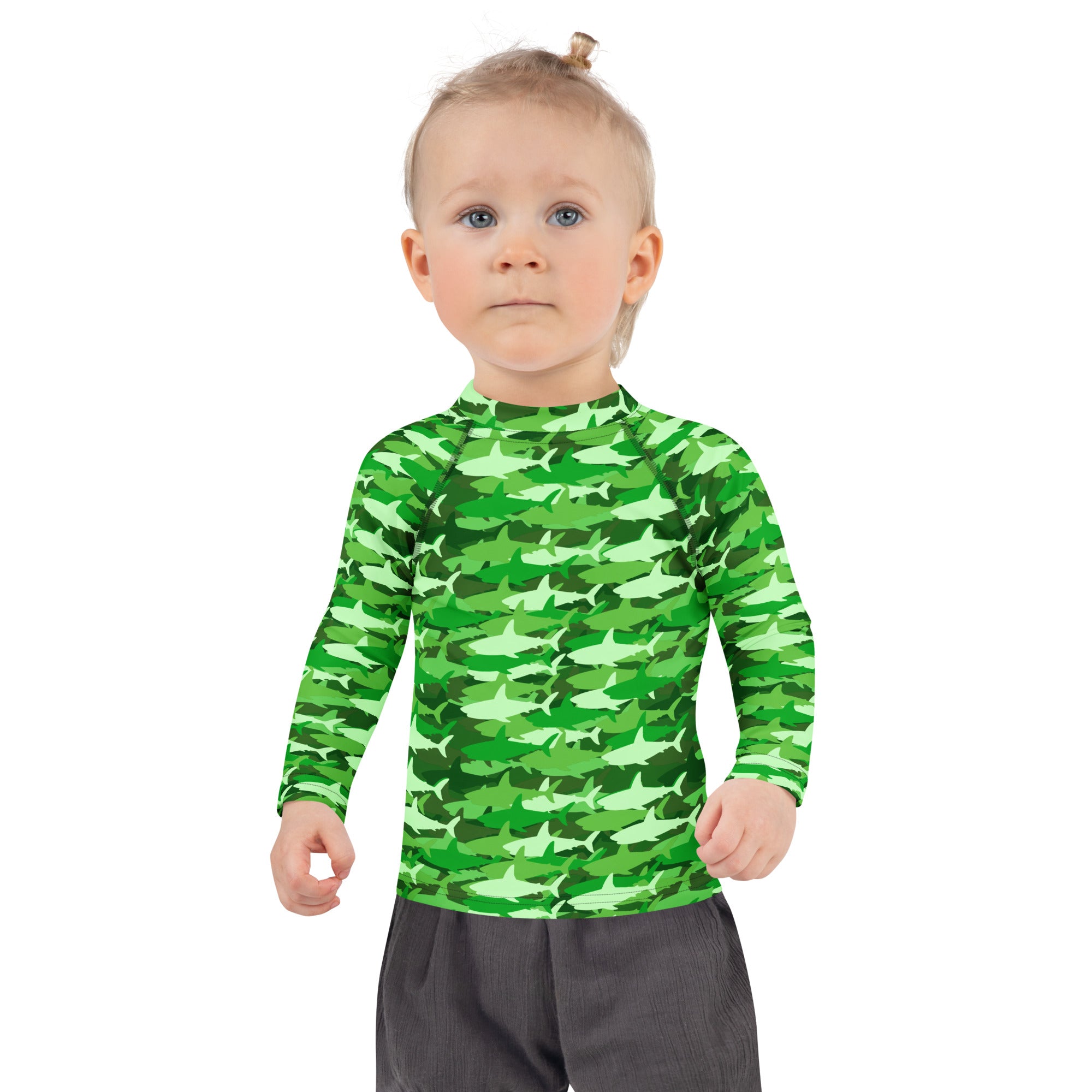 A child wearing a kids green shark long sleeve rash guard swim shirt with upf 50 plus for sun protection