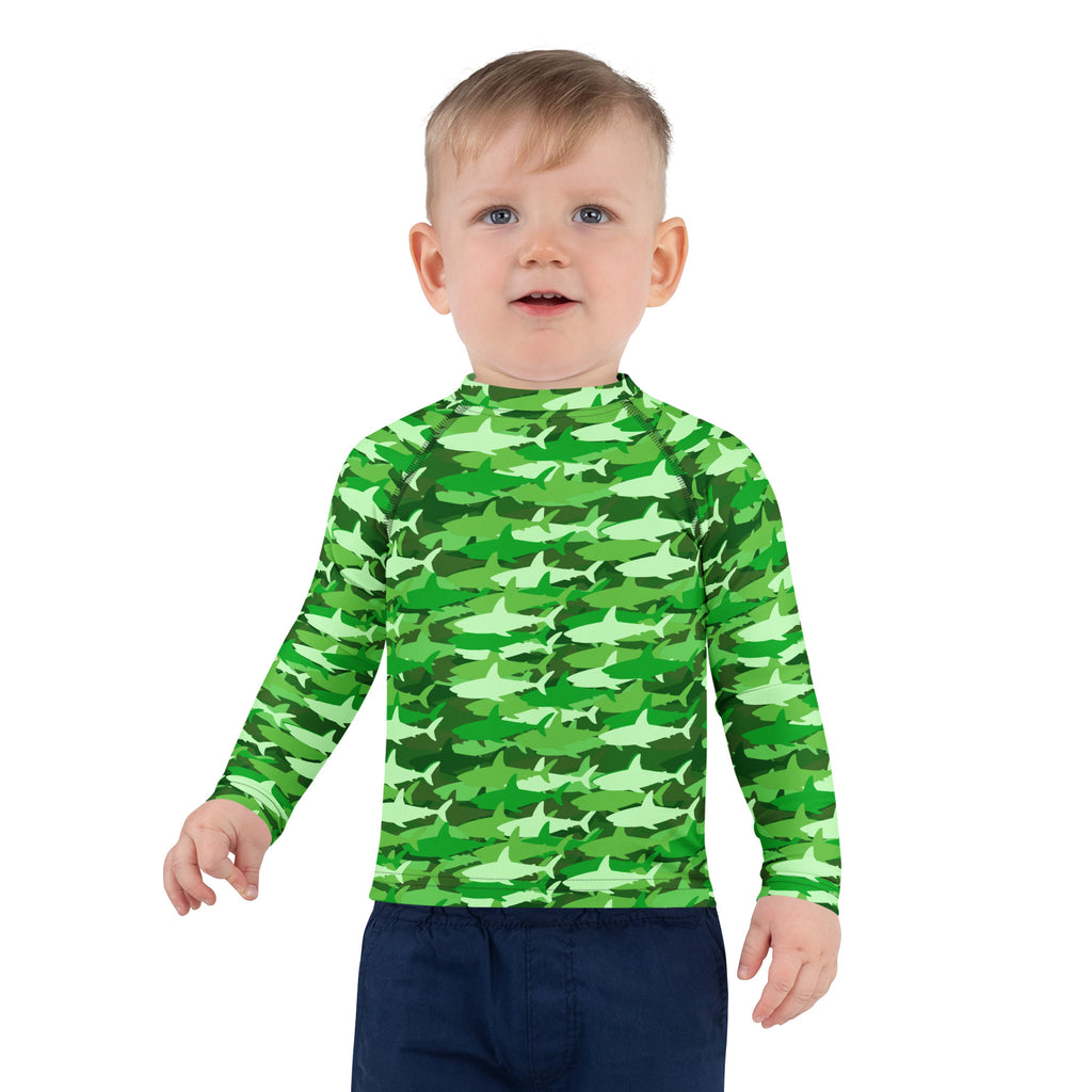 A child wearing a green shark camouflage long sleeve rash guard swim shirt with upf 50 plus protection