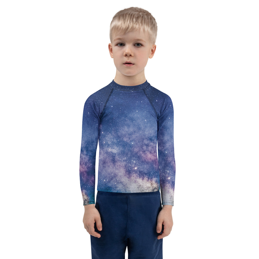 A child wearing a kids realistic galaxy long sleeve rash guard swim shirt with UPF 50 plus in blue and purple
