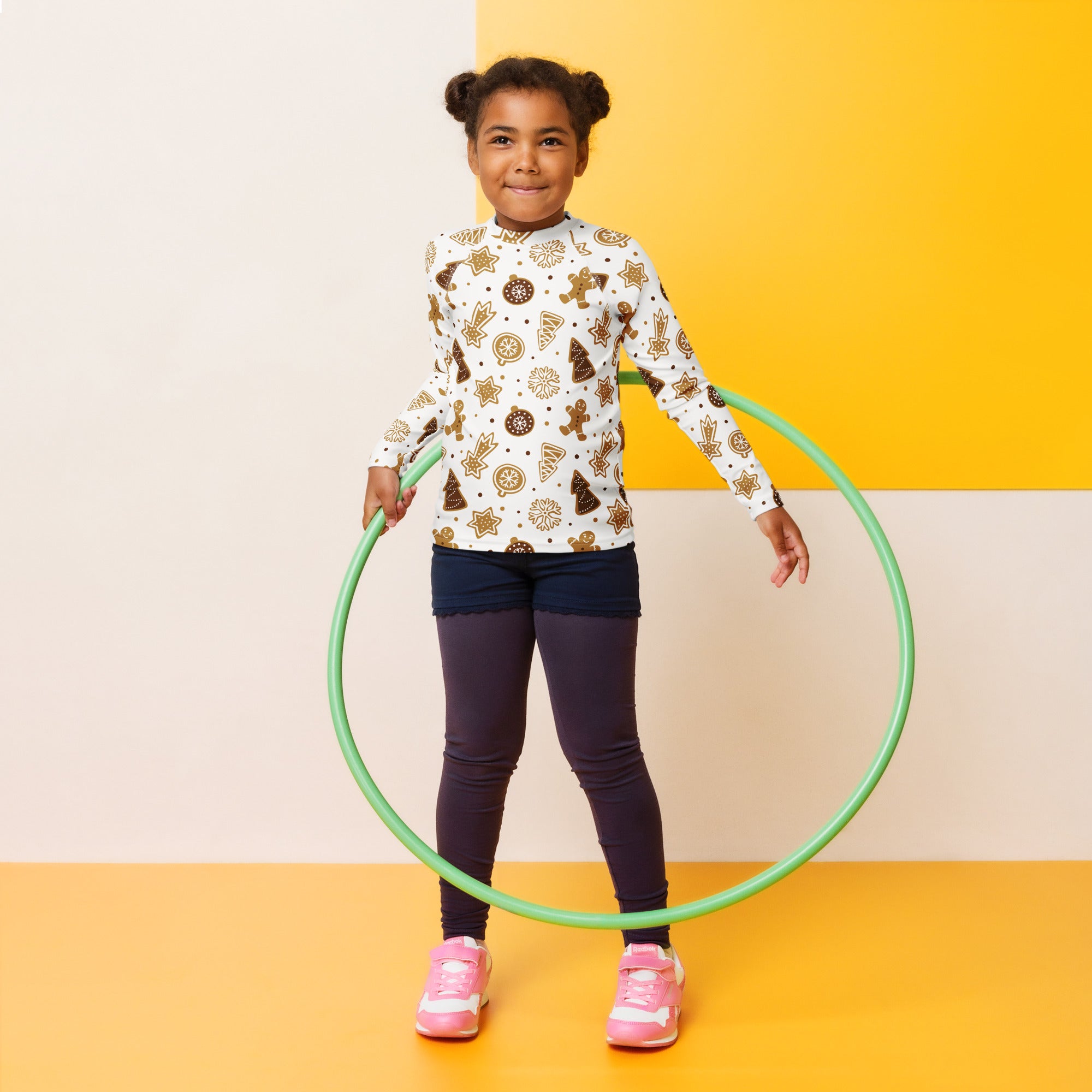 Green plastic hula hoop shown with a kids gingerbread cookies christmas long sleeve rash guard swim shirt with upf 50+
