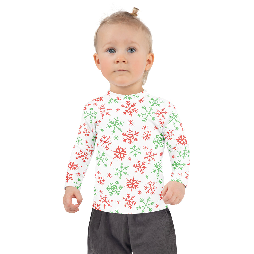 A child wearing a kids red and green snowflakes Christmas long sleeve rash guard swim shirt with UPF 50+ protection