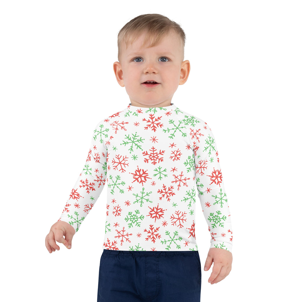 A child wearing a kids red and green snowflakes christmas long sleeve rash guard swim shirt with upf 50+