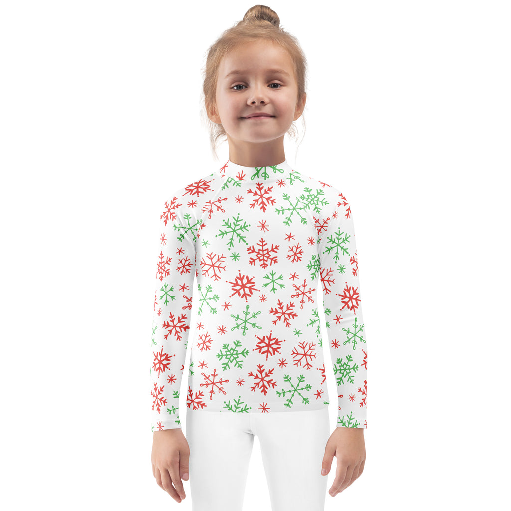 A white long-sleeved kids rash guard swim shirt with red and green snowflakes and upf 50 plus protection