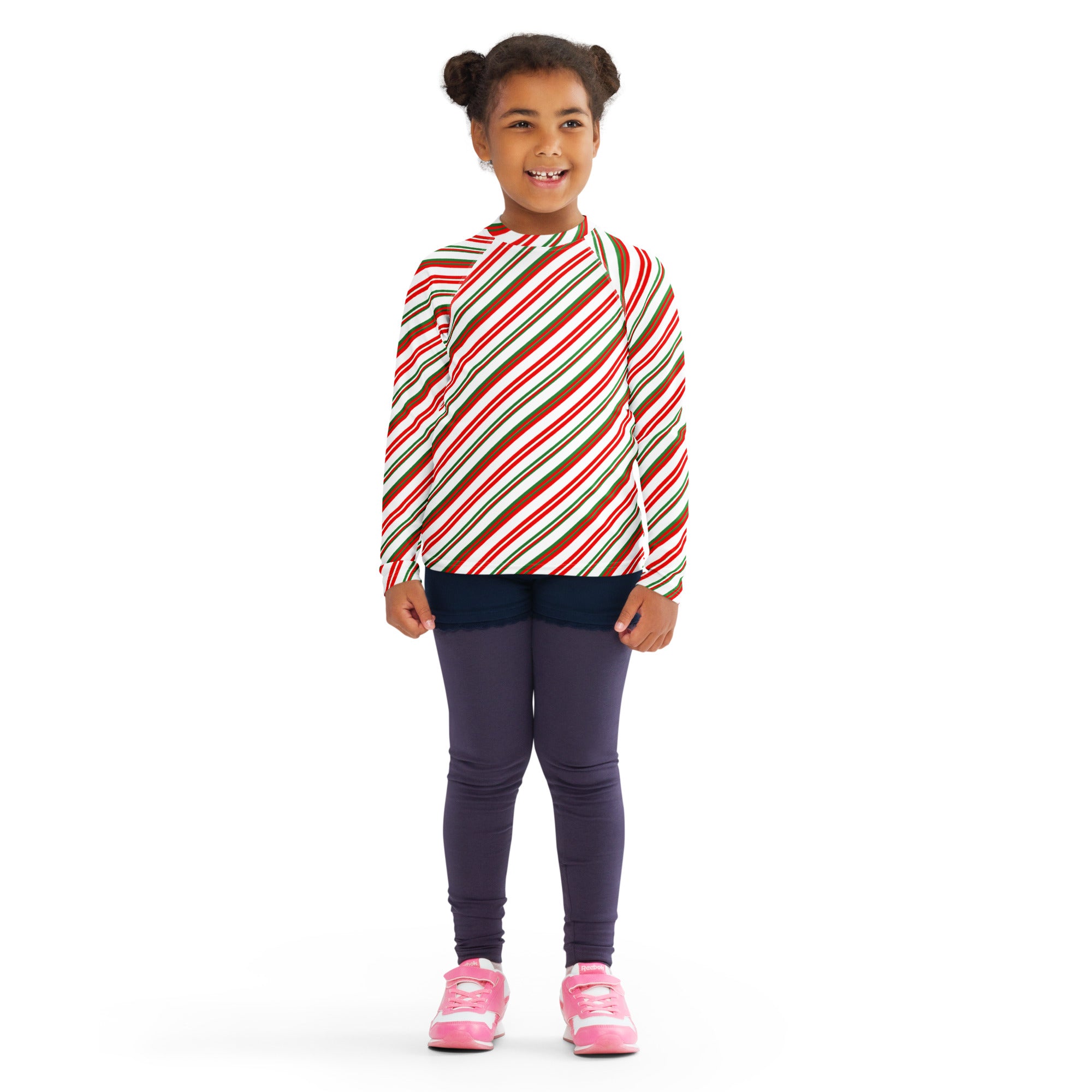 A child wearing a kids candy cane stripe christmas long sleeve rash guard swim shirt with upf 50 plus in red white and brown