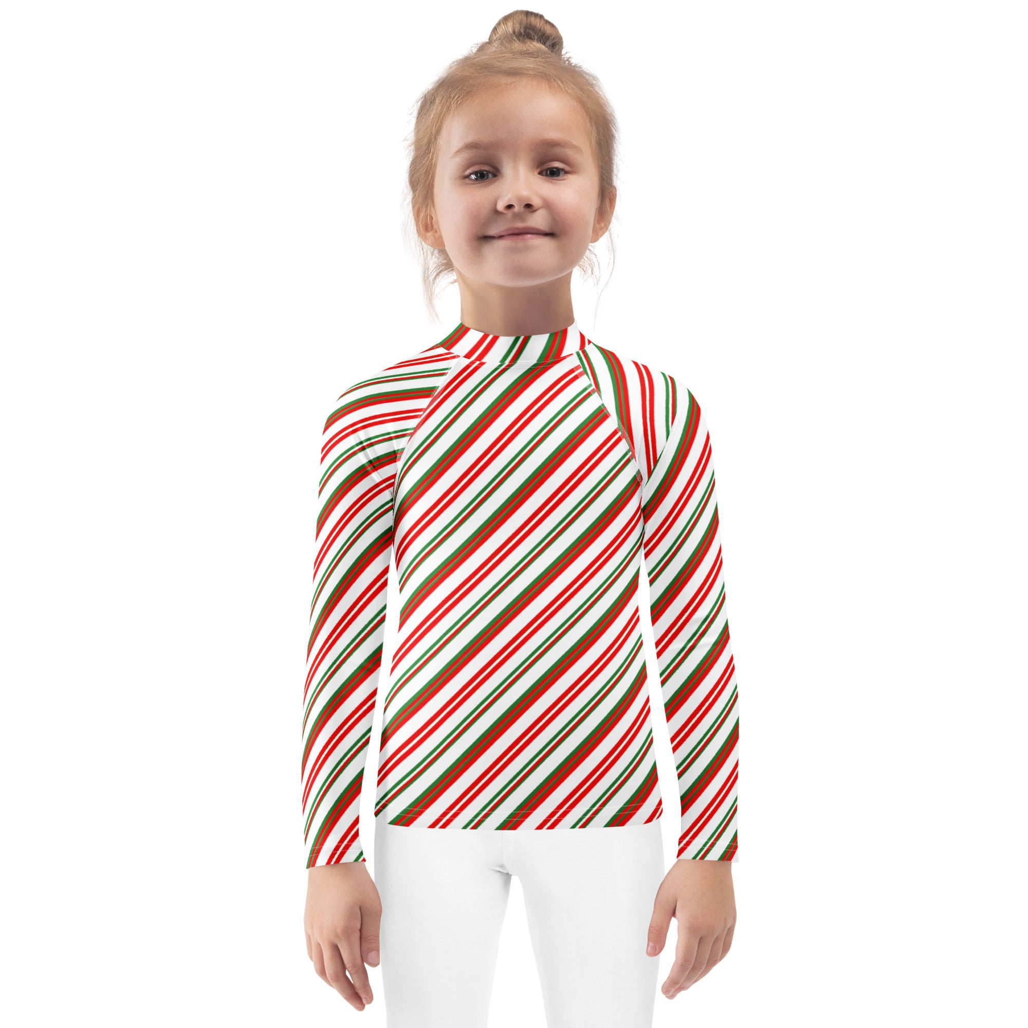 A child wearing a kids candy cane stripe christmas long sleeve rash guard swim shirt with red green and white diagonal stripes and upf 50+