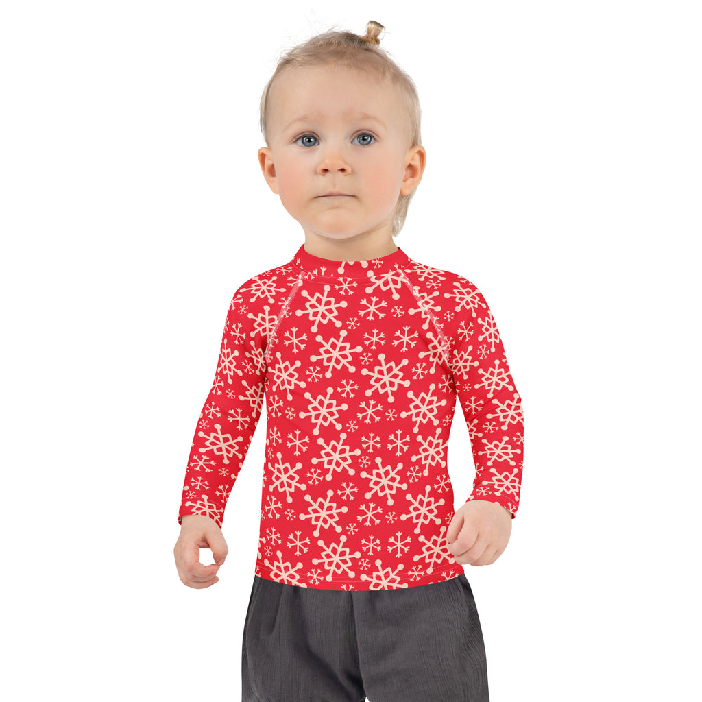 Kids red long-sleeved rash guard swim shirt with white snowflake pattern and UPF 50 plus for sun protection