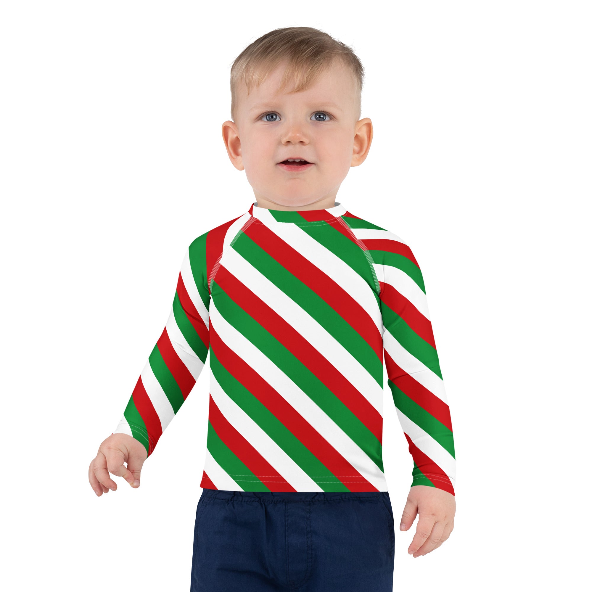 A child wearing a kids bold candy cane stripe christmas rash guard swim shirt with red green and white diagonal stripes