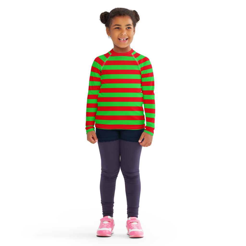 A child wearing a kids red and green striped Christmas long sleeve rash guard swim shirt with UPF 50 plus