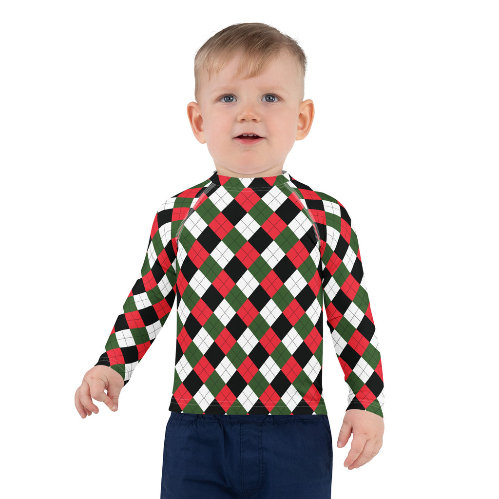 A child wearing a kids Christmas argyle long sleeve rash guard swim shirt with red green black white pattern and UPF 50+