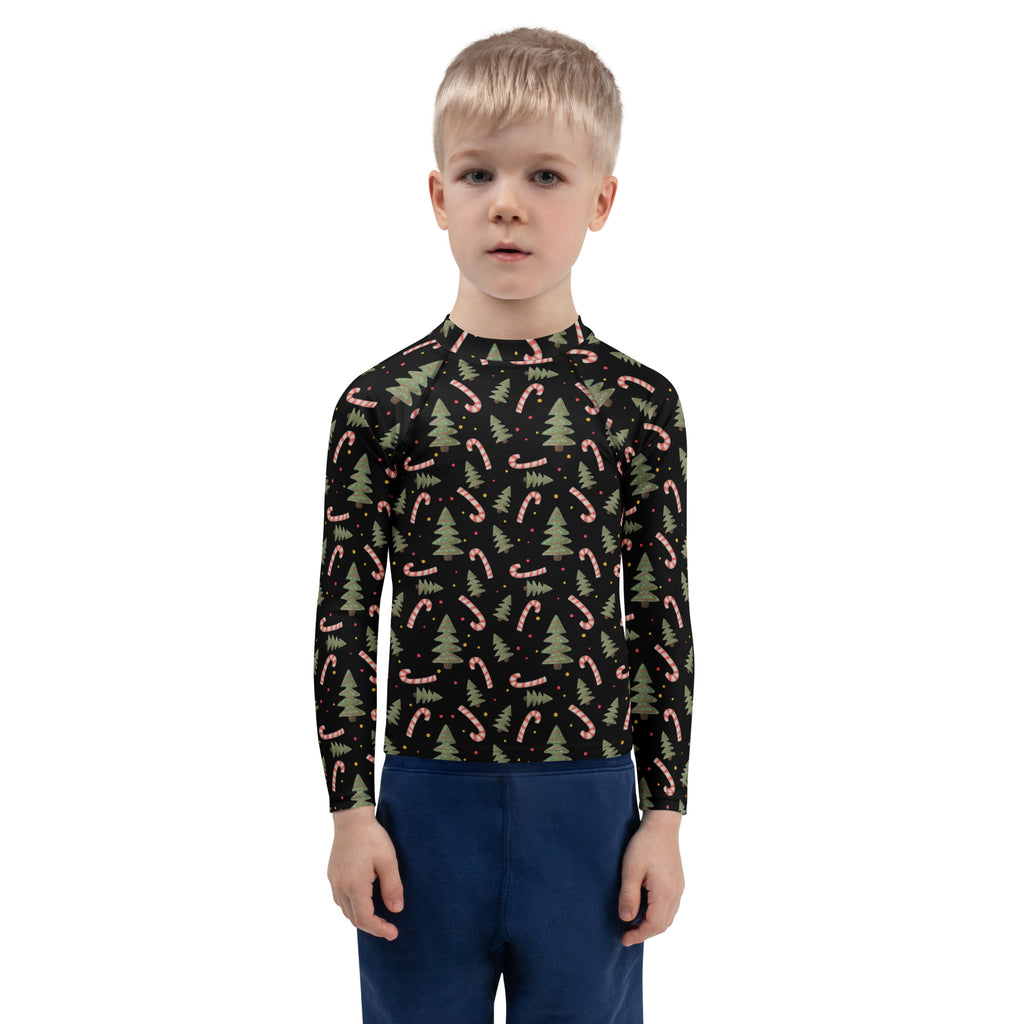 Black long sleeve rash guard for kids with UPF 50 plus featuring pink candy canes and green pine trees festive pattern