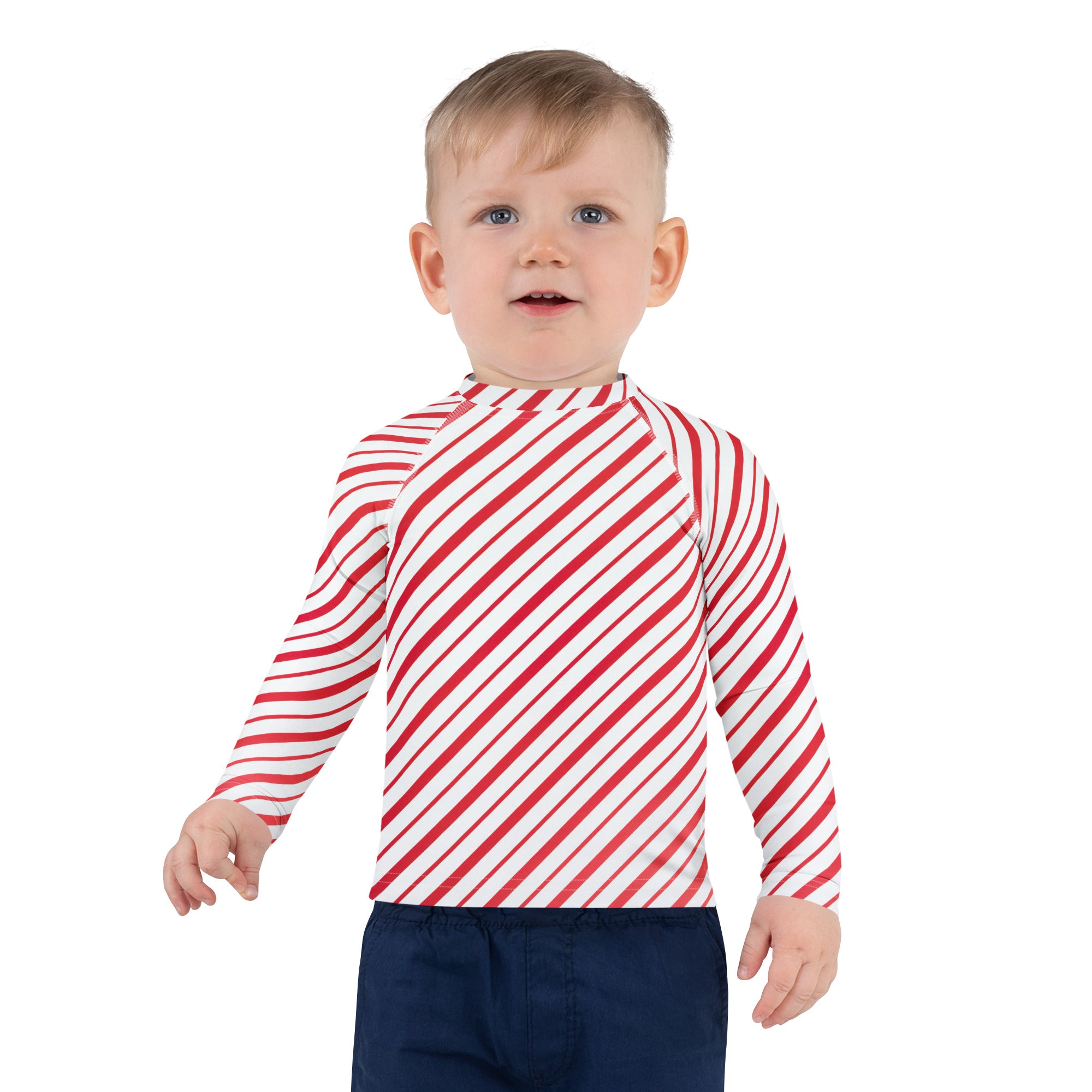 A child wearing a kids red and white candy cane striped long sleeve rash guard swim shirt with UPF 50+ protection