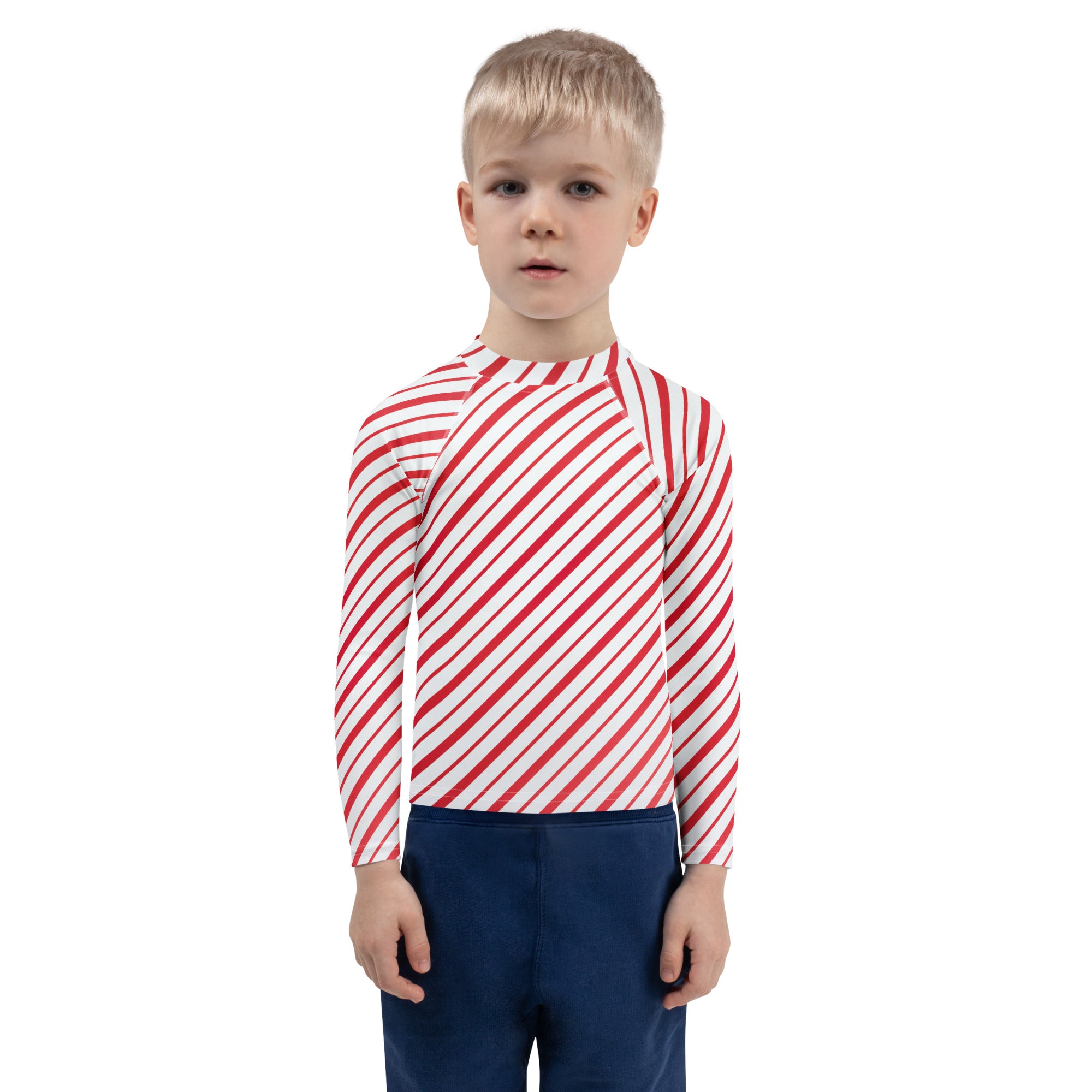 A child wearing a kids red and white candy cane striped long sleeve rash guard swim shirt with UPF 50+ protection
