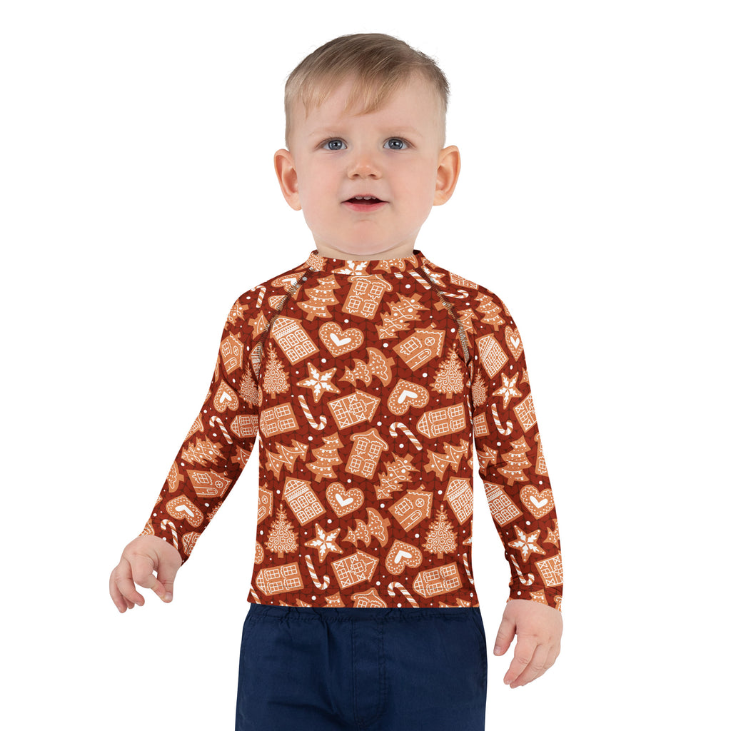 A child wearing a kids red gingerbread christmas long sleeve rash guard swim shirt with upf 50 plus and festive pattern