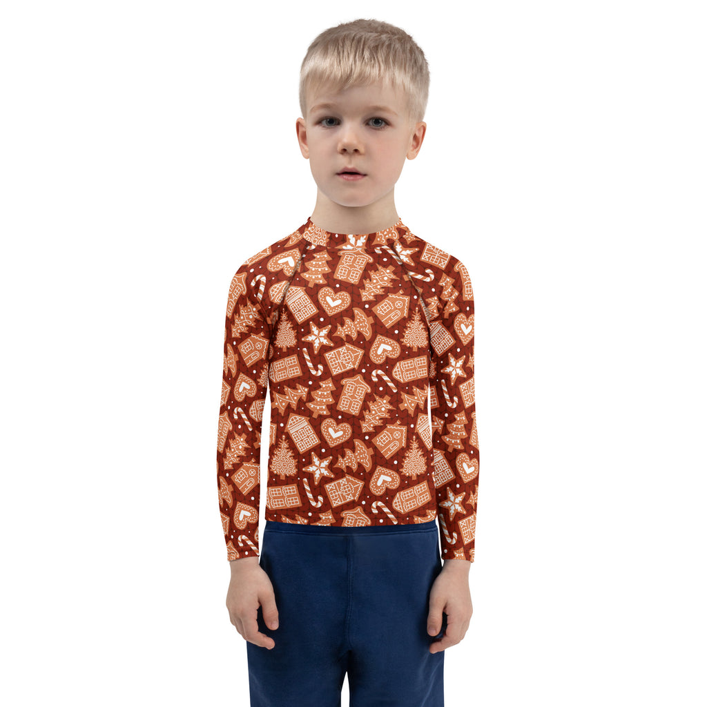 A child wearing a rust-colored kids red gingerbread christmas long sleeve rash guard swim shirt with upf 50 and festive pattern