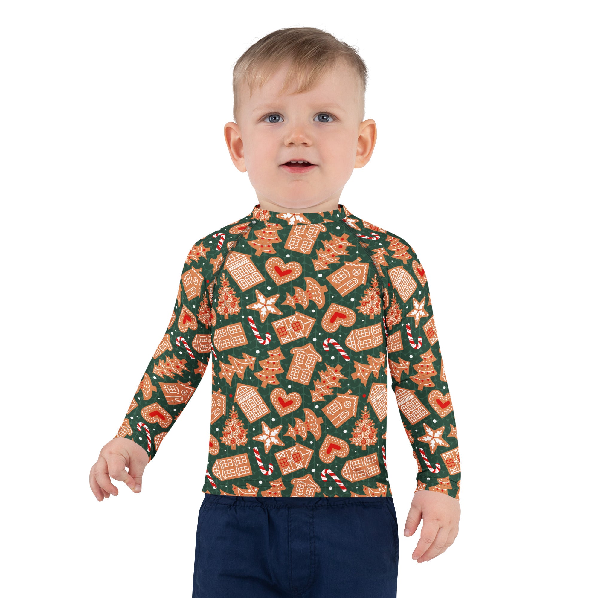 A child wearing a kids green gingerbread christmas long sleeve rash guard swim shirt with upf 50 plus and festive pattern