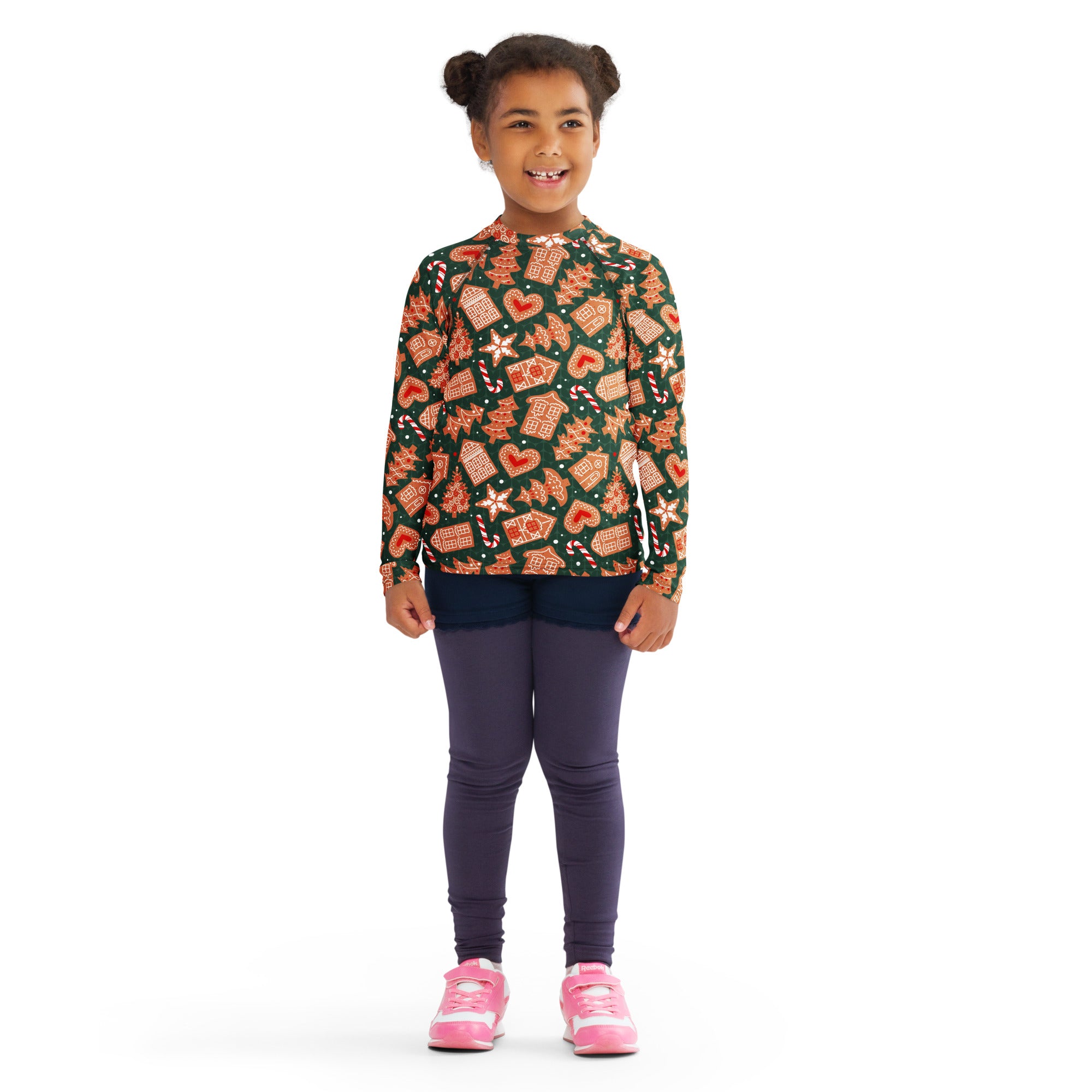 A child wearing a kids green gingerbread christmas long sleeve rash guard swim shirt with upf 50 plus and festive patterns