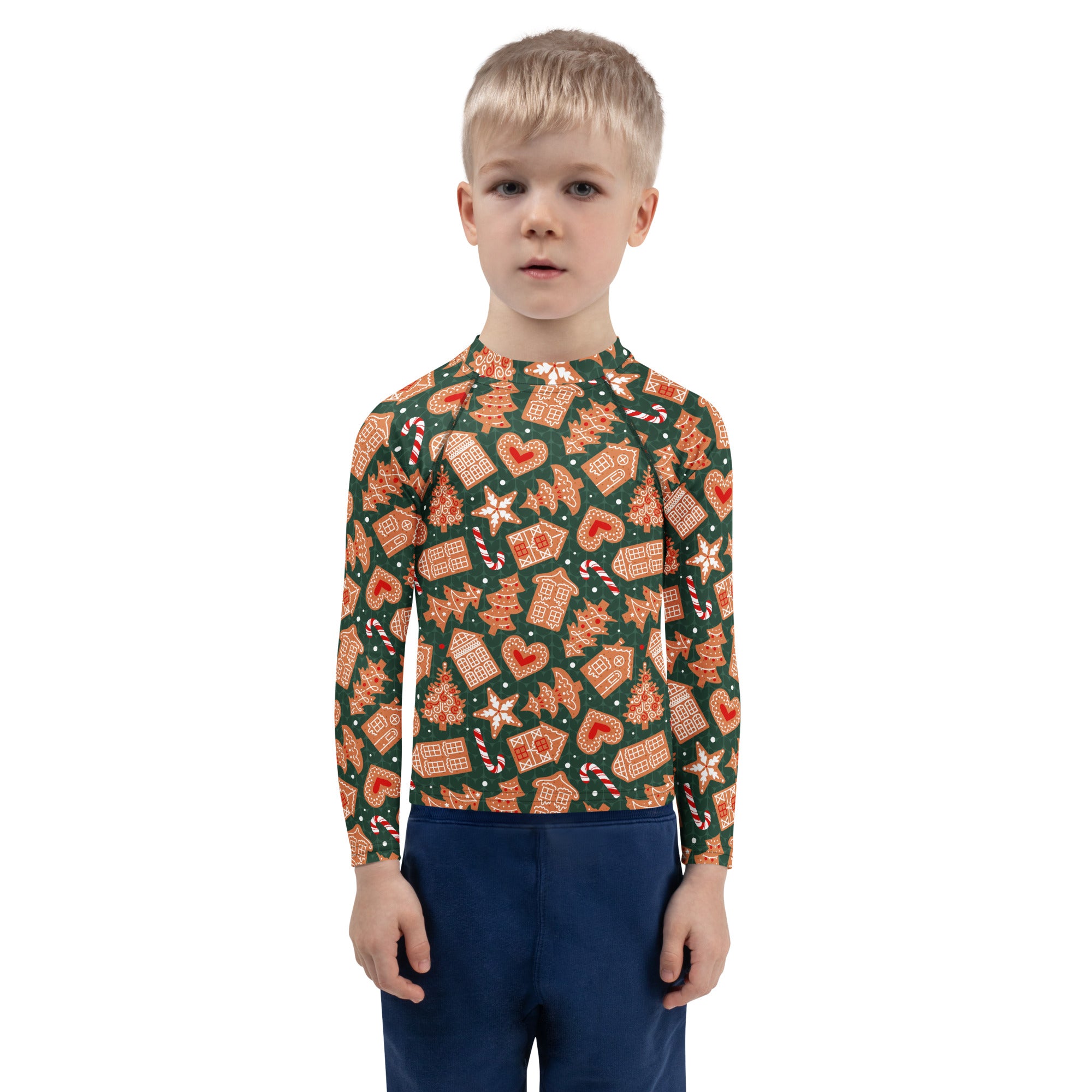 A child wearing a kids green gingerbread christmas long sleeve rash guard swim shirt with upf 50 and festive patterns