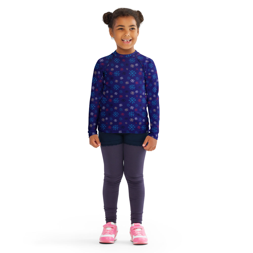 A child wearing a kids navy snowflake Christmas long sleeve rash guard swim shirt with UPF 50+ protection