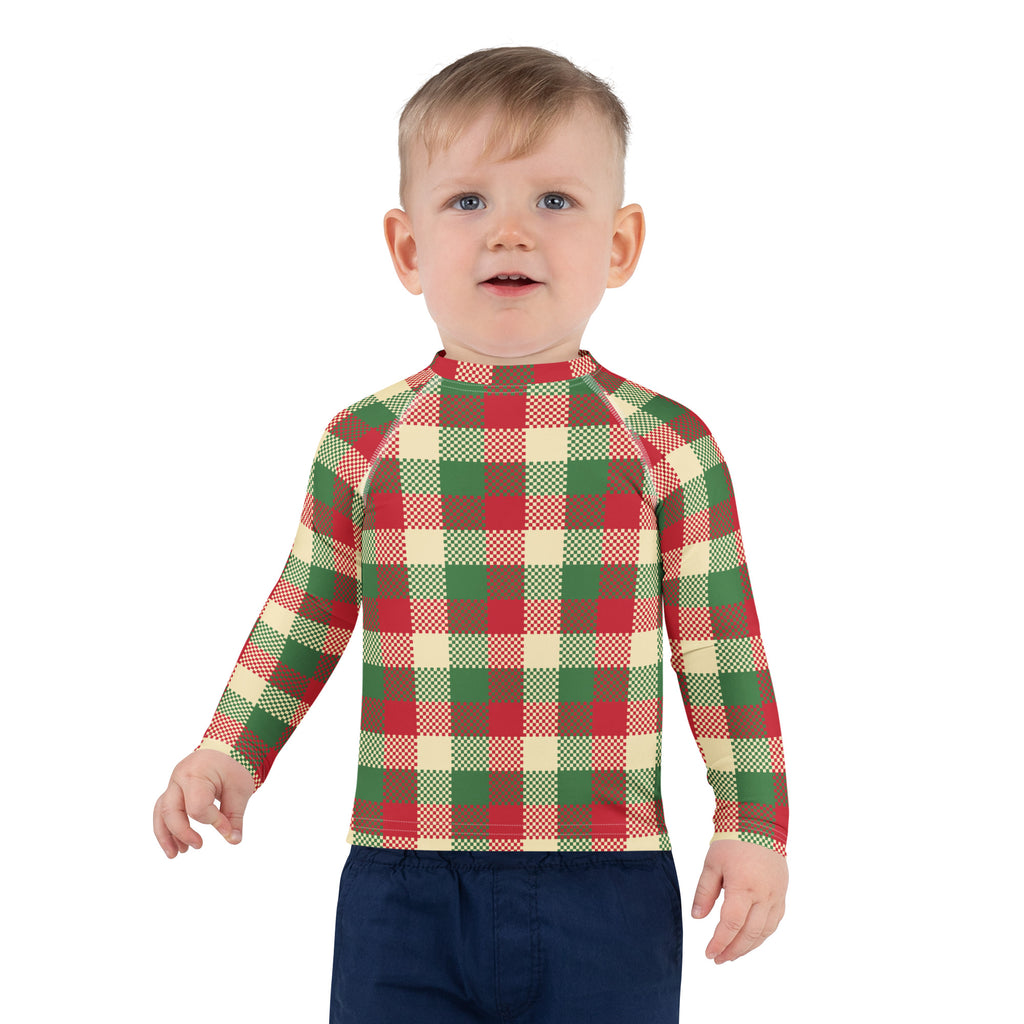 A child wearing a kids christmas plaid long sleeve rash guard swim shirt with upf 50 plus in red green and cream
