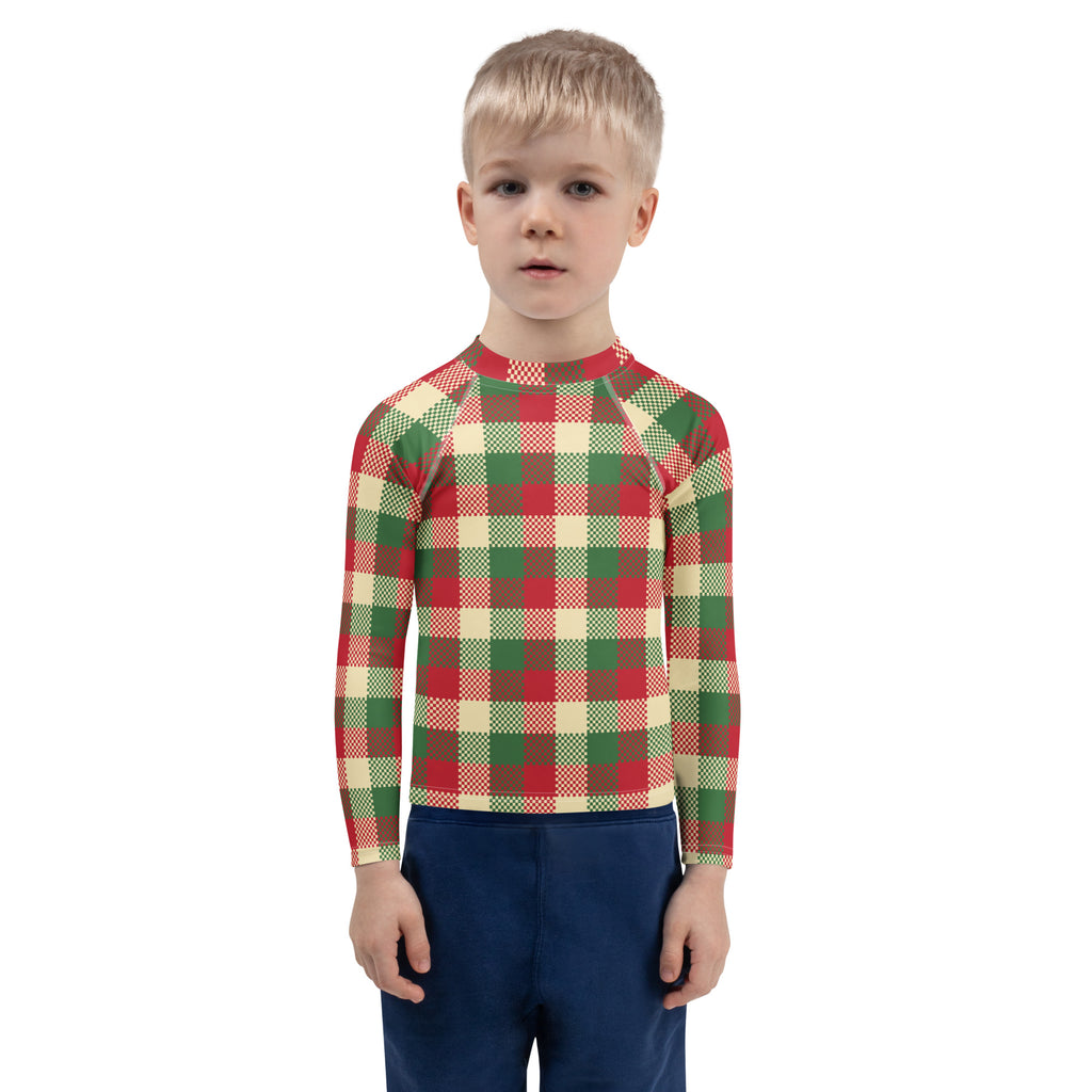 A child wearing a kids christmas plaid long sleeve rash guard swim shirt with upf 50 plus in red green and beige