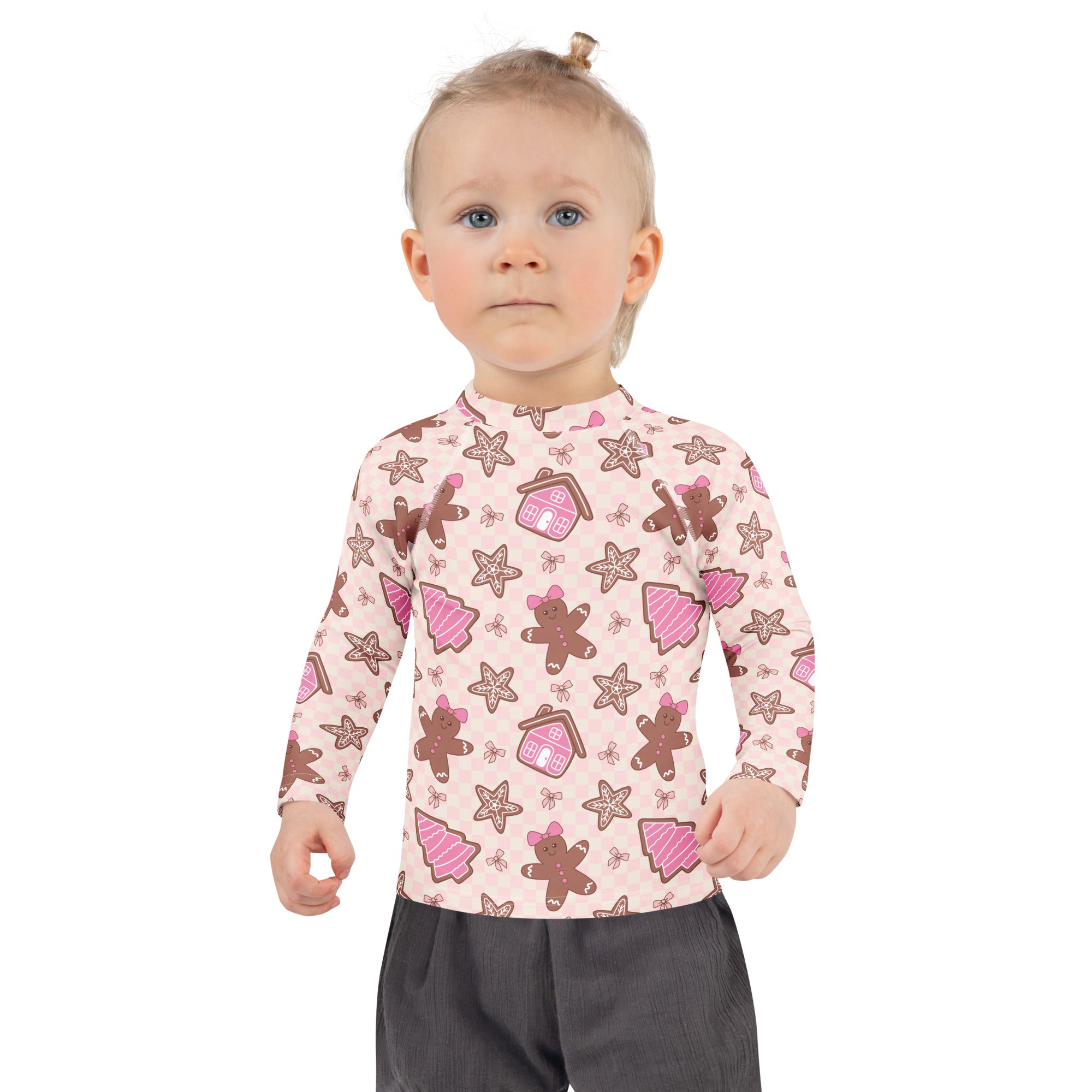A child wearing a kids pink gingerbread Christmas long sleeve rash guard swim shirt with UPF 50 plus protection