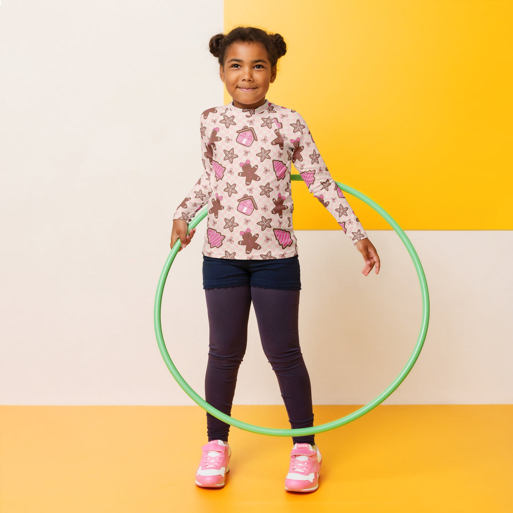 Green plastic hula hoop beside kids pink gingerbread christmas long sleeve rash guard swim shirt with upf 50 plus