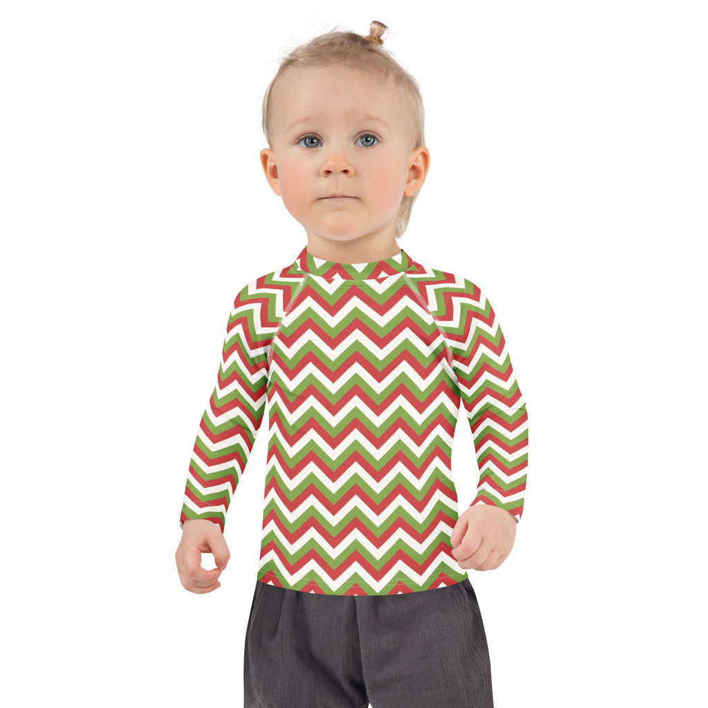 A child wearing a kids red and green chevron Christmas long sleeve rash guard swim shirt with UPF 50 plus protection