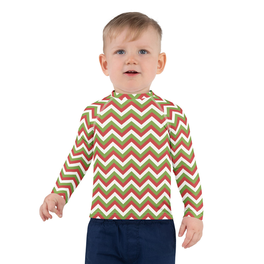 A child wearing a kids red and green chevron christmas long sleeve rash guard swim shirt with upf 50 plus