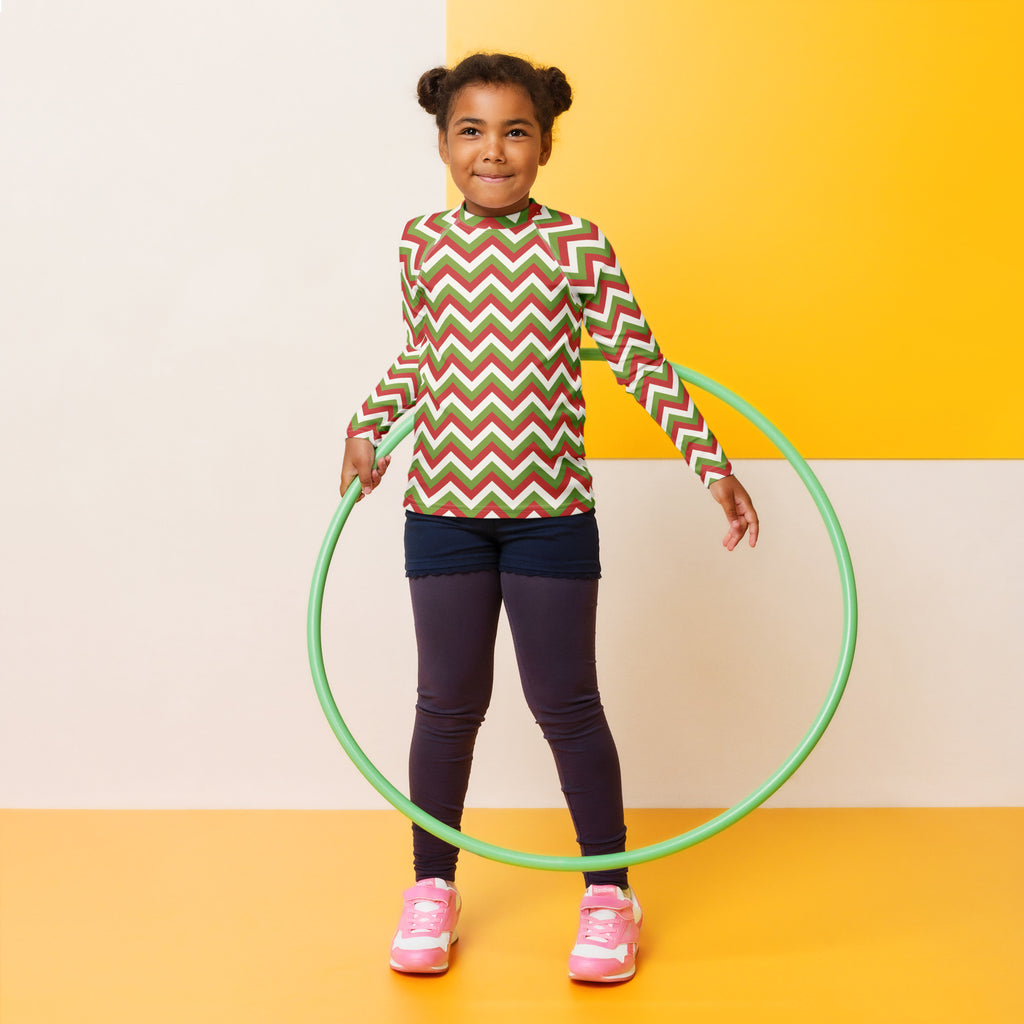 Green plastic hula hoop displayed alongside kids red and green chevron christmas long sleeve rash guard swim shirt with upf 50+