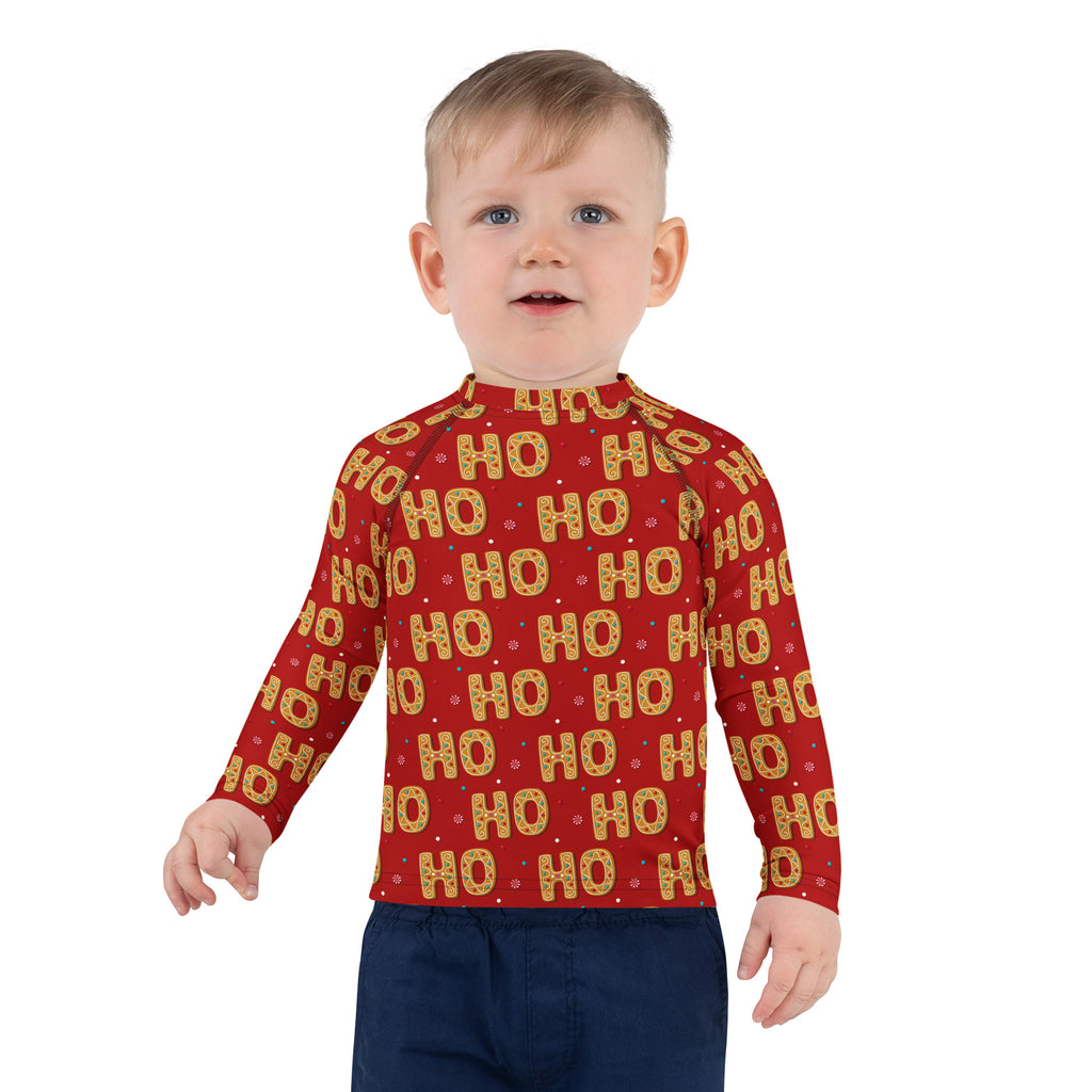 Red long-sleeved kids rash guard with gold and white ho ho pattern, upf 50 plus for sun protection