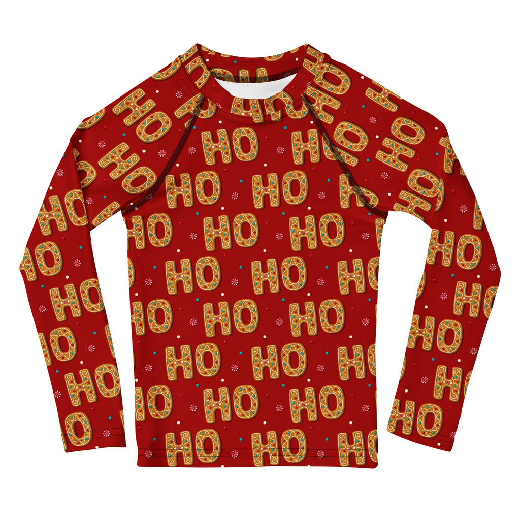 Red long-sleeved kids rash guard with festive golden ho ho ho cookie letters and snowflake accents with UPF 50+ protection