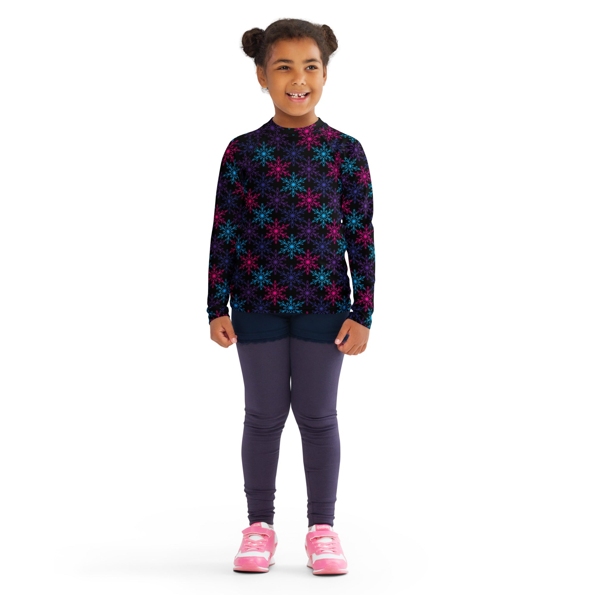 A child wearing a kids neon snowflakes christmas long sleeve rash guard swim shirt with vibrant multicolored snowflake pattern and upf 50+
