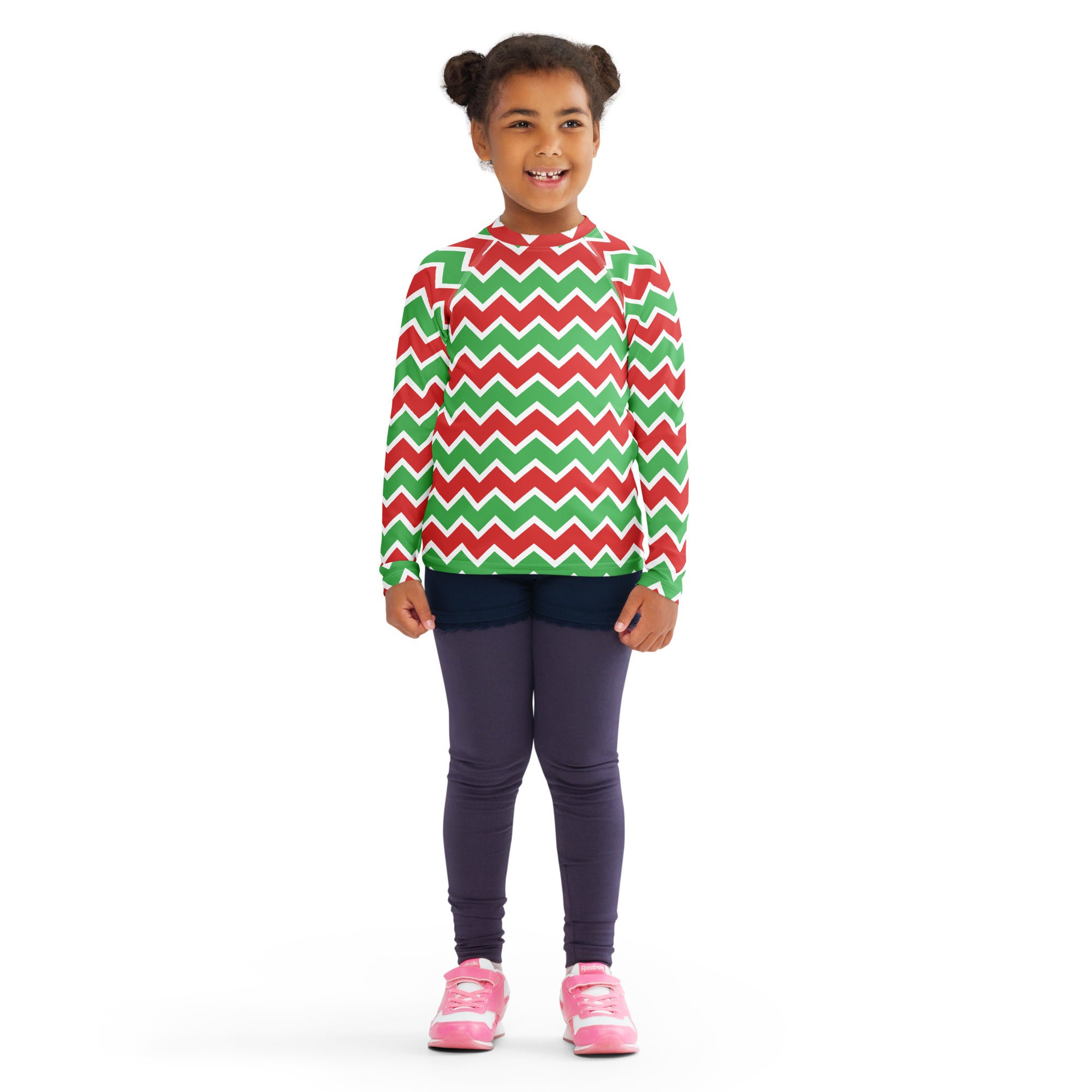 A child wearing a kids christmas chevron long sleeve rash guard swim shirt with red green zigzag pattern and UPF 50+
