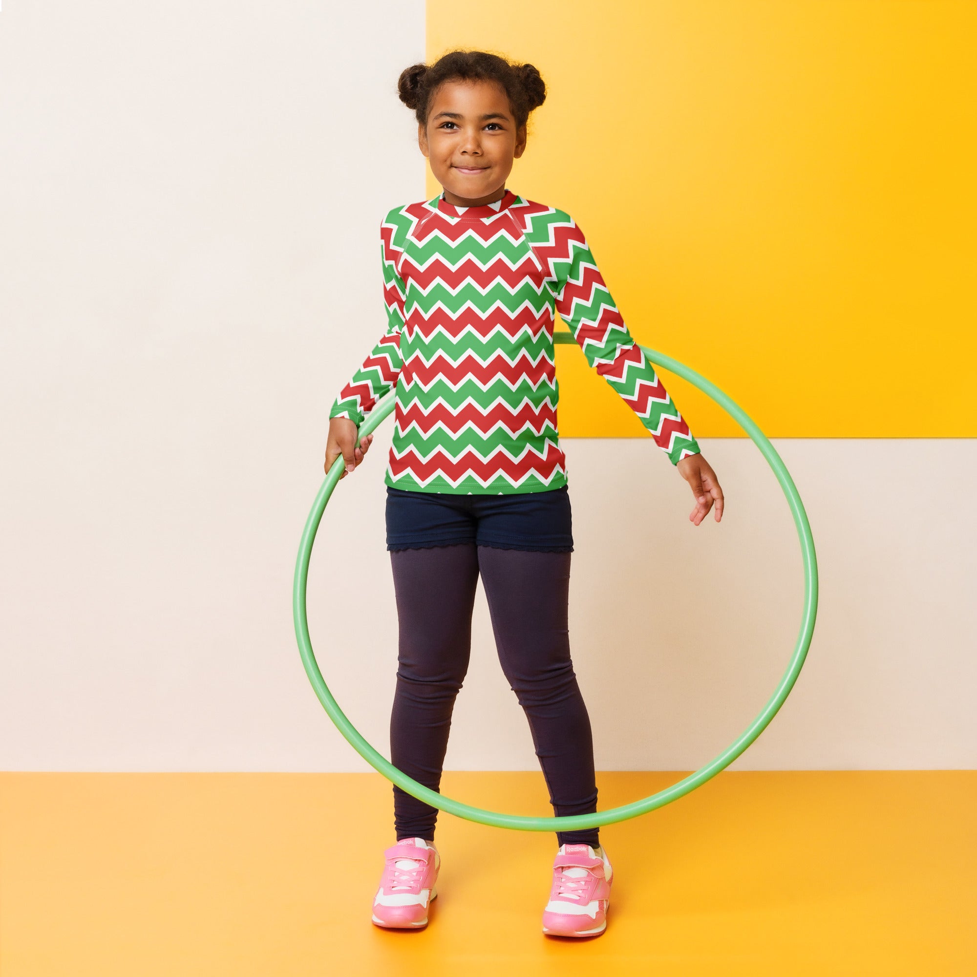 Green plastic hula hoop alongside kids christmas chevron long sleeve rash guard swim shirt with upf 50 plus