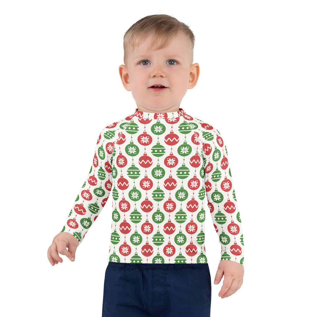 A child wearing a kids red and green christmas ornament long sleeve rash guard swim shirt with upf 50 plus