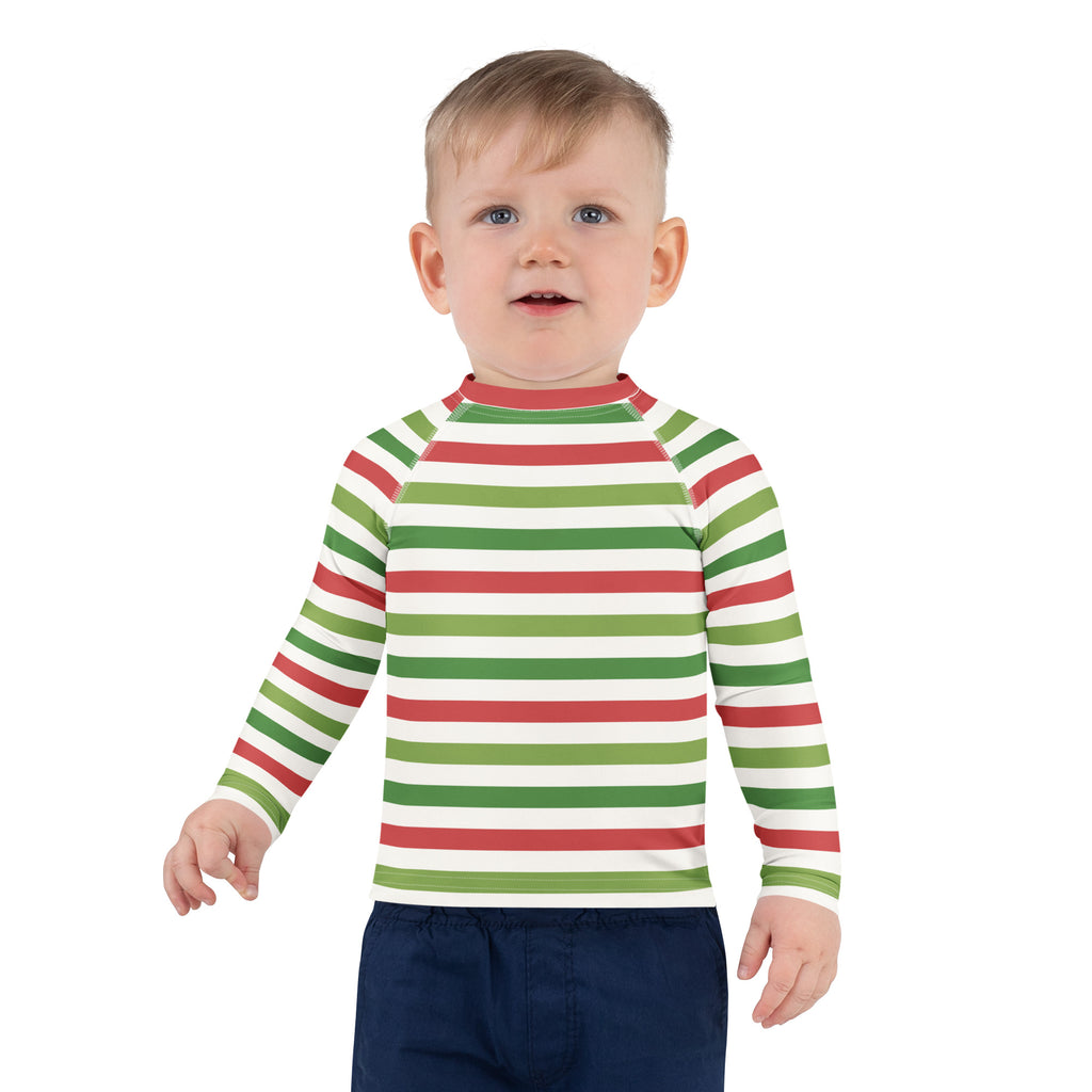 A child wearing a kids red and green christmas stripes long sleeve rash guard swim shirt with upf 50+