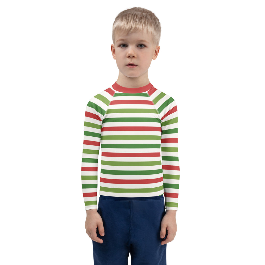 A child wearing a kids red and green christmas stripes long sleeve rash guard swim shirt with upf 50 plus