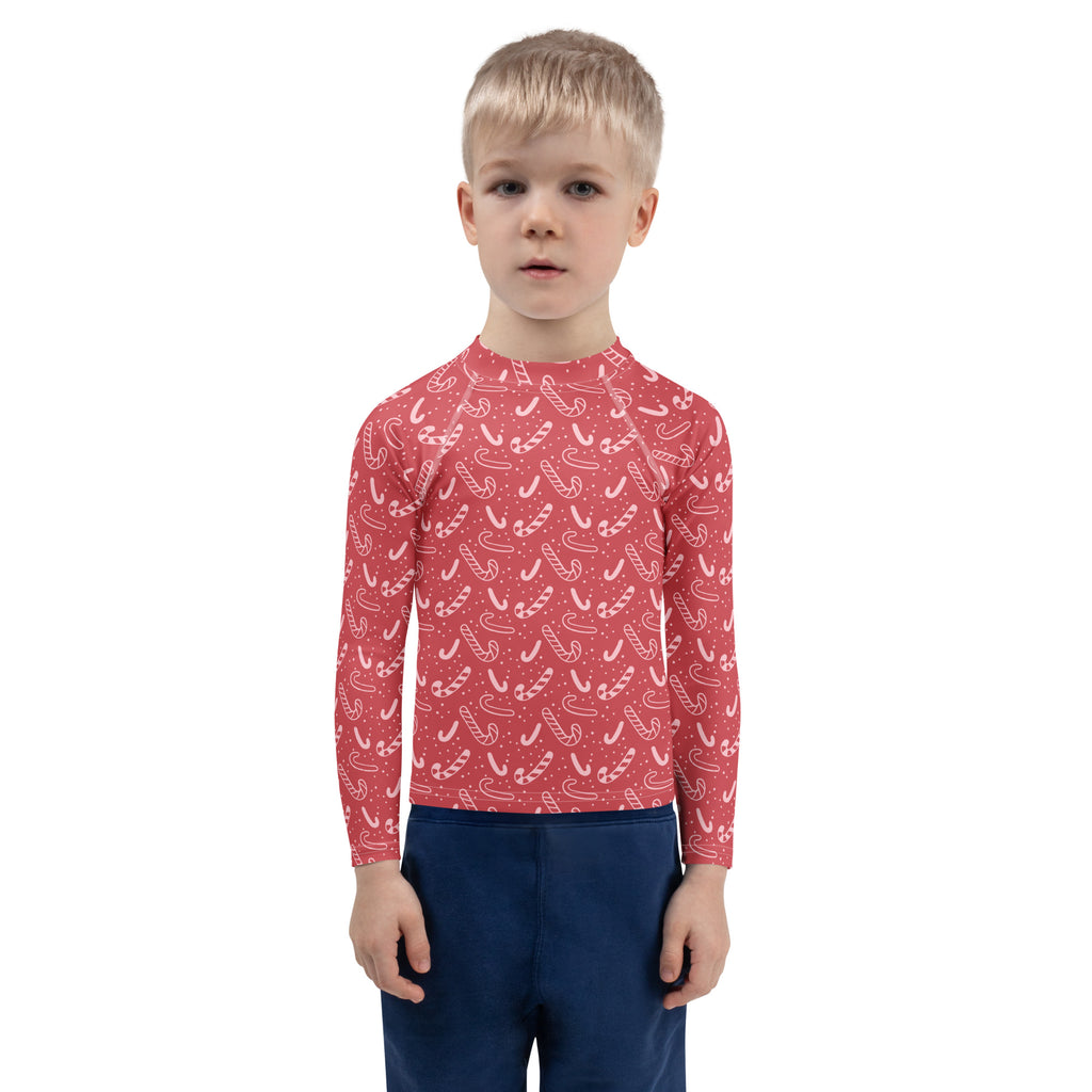 Kids red long sleeve rash guard swim shirt with white candy cane pattern and UPF 50 plus for sun protection