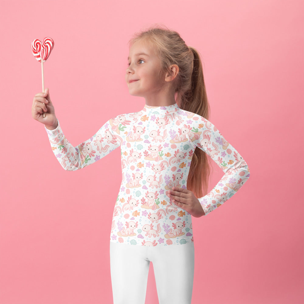 A girl wearing a white girls axolotl long sleeve rash guard swim shirt with upf 50 plus and pastel sea creatures pattern