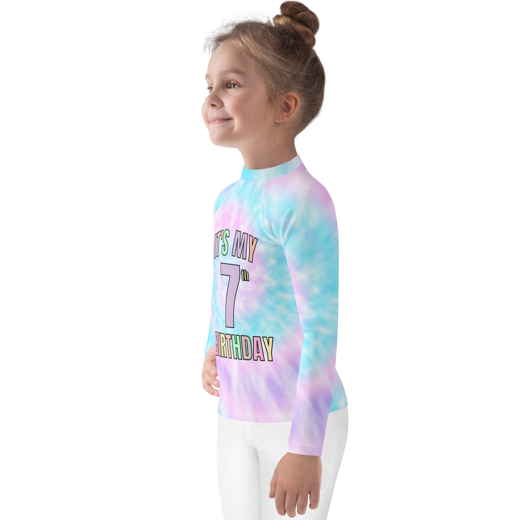 A child wearing a girls tie dye custom age it’s my birthday rash guard swim shirt in pastel blue and purple swirl colors