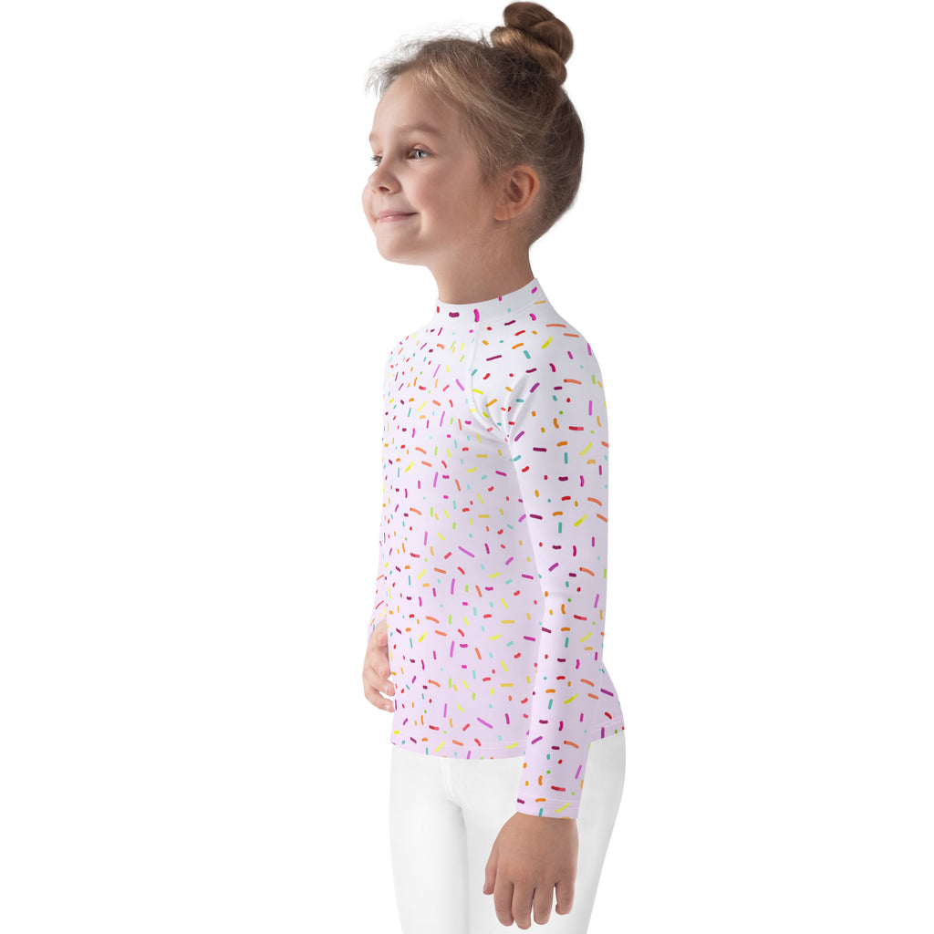A white kids long sleeve rash guard swim shirt with colorful sprinkles and UPF 50 plus sun protection