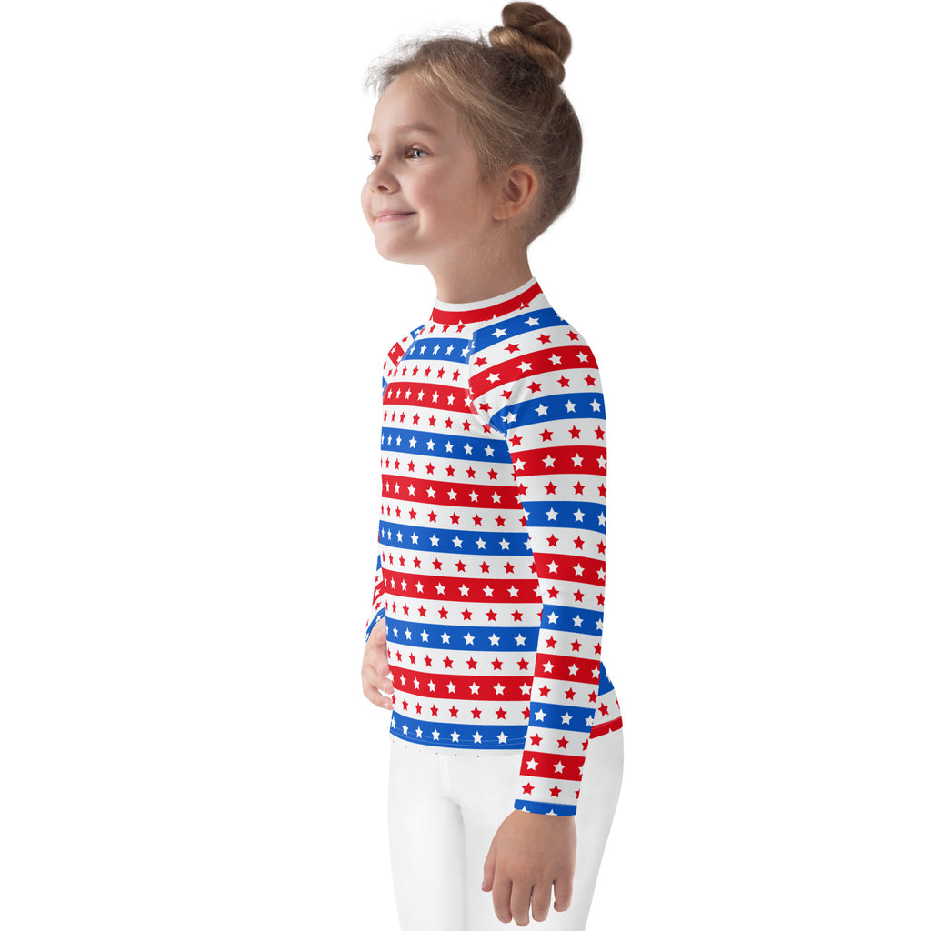 A child wearing a kids red white and blue stars and stripes usa long sleeve rash guard with upf 50 and horizontal stripes